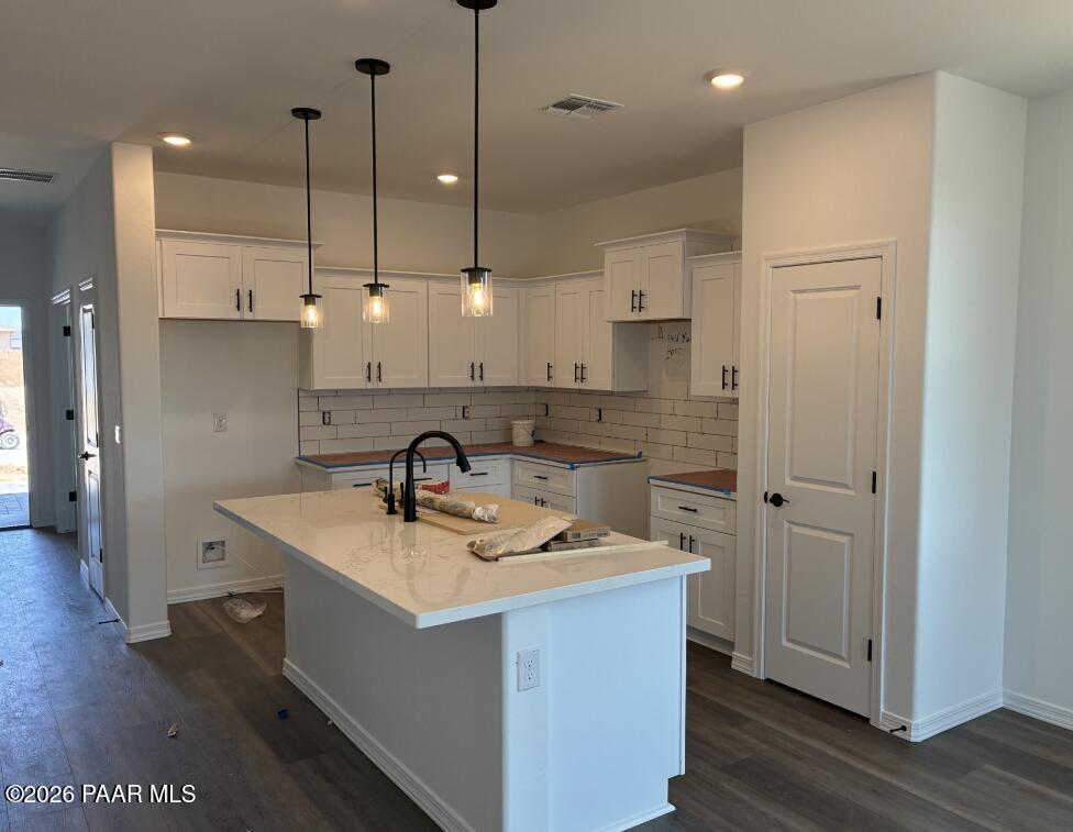 Modern kitchen with white cabinets, quartz island, and pendant lighting in The Coronado A home, South Ranch, Prescott, AZ.