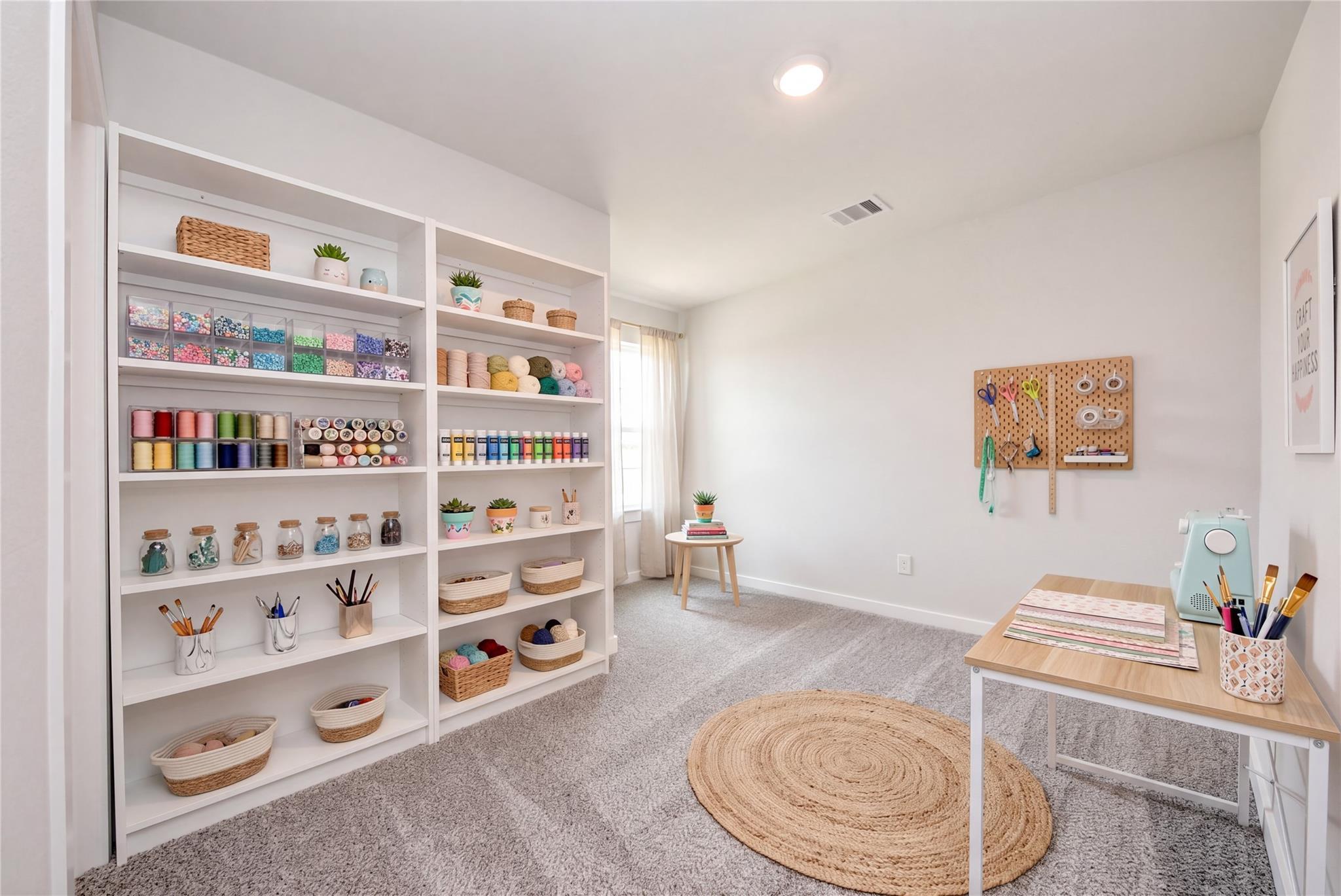 Dedicated craft room with organized shelving, pegboard, and workstation in The Sabine E floor plan, Windmill Estates.