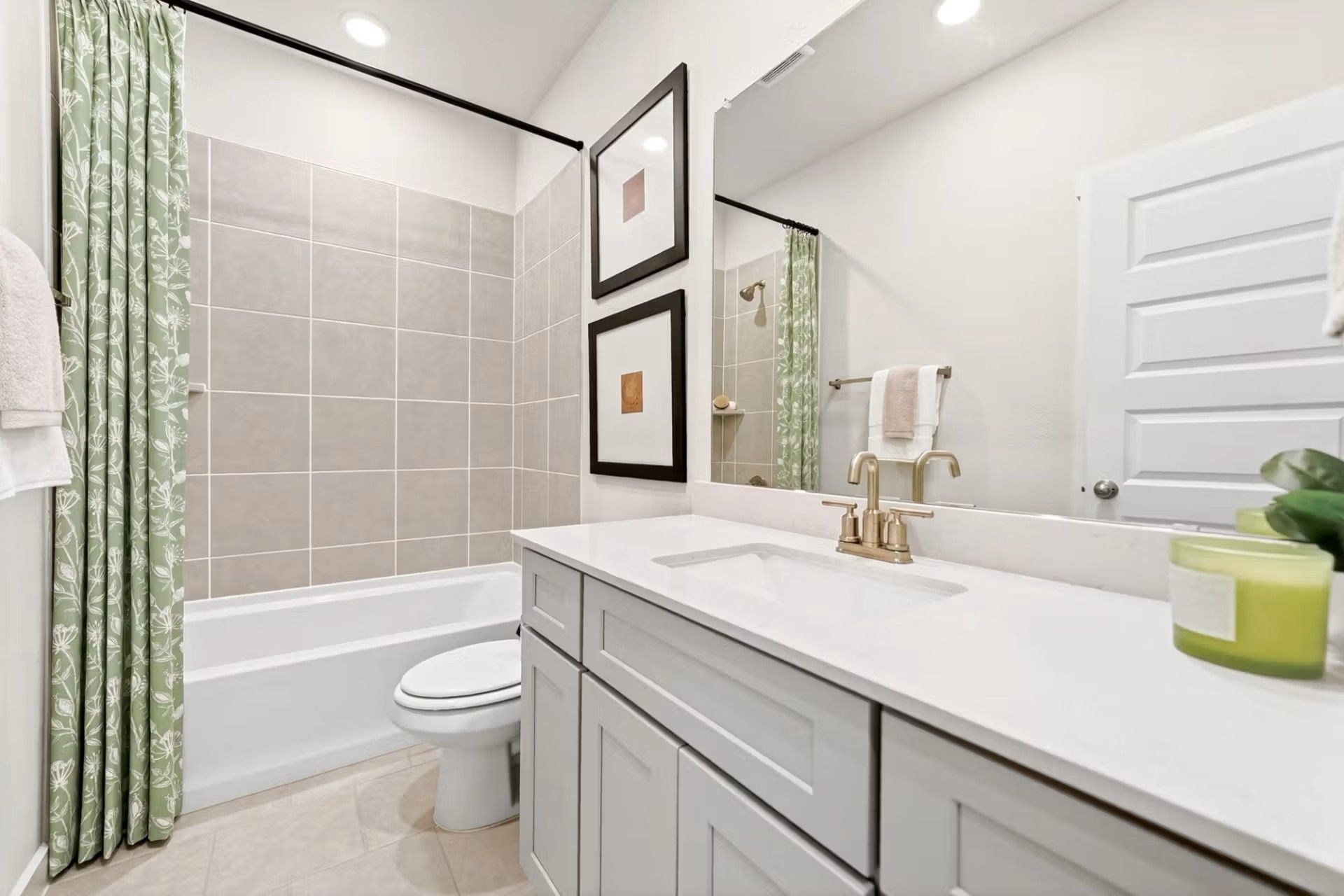 Modern bathroom with vanity, tiled shower-tub combo, and gold fixtures in a Davidson Homes Laurel I floor plan in Heartland.