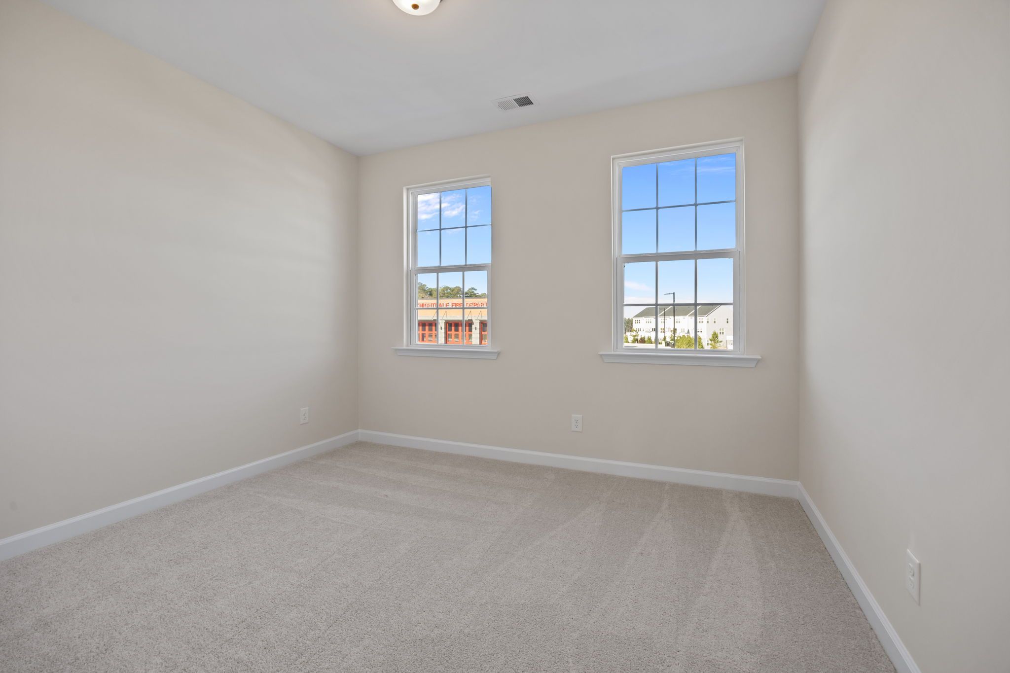Spacious bedroom with neutral carpet and natural light in a Davidson Homes house at Forestville Yard in Knightdale, NC.