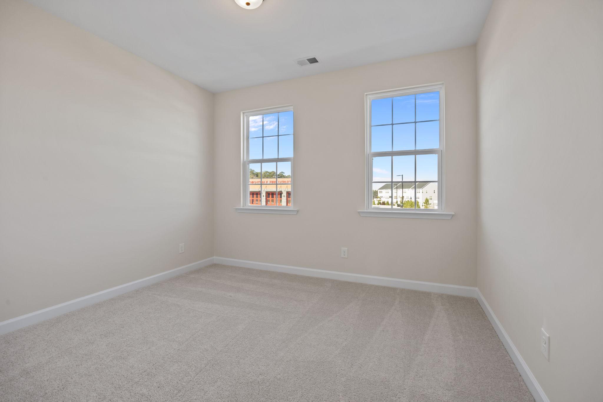 Spacious bedroom with neutral carpet and natural light in a Davidson Homes house at Forestville Yard in Knightdale, NC.