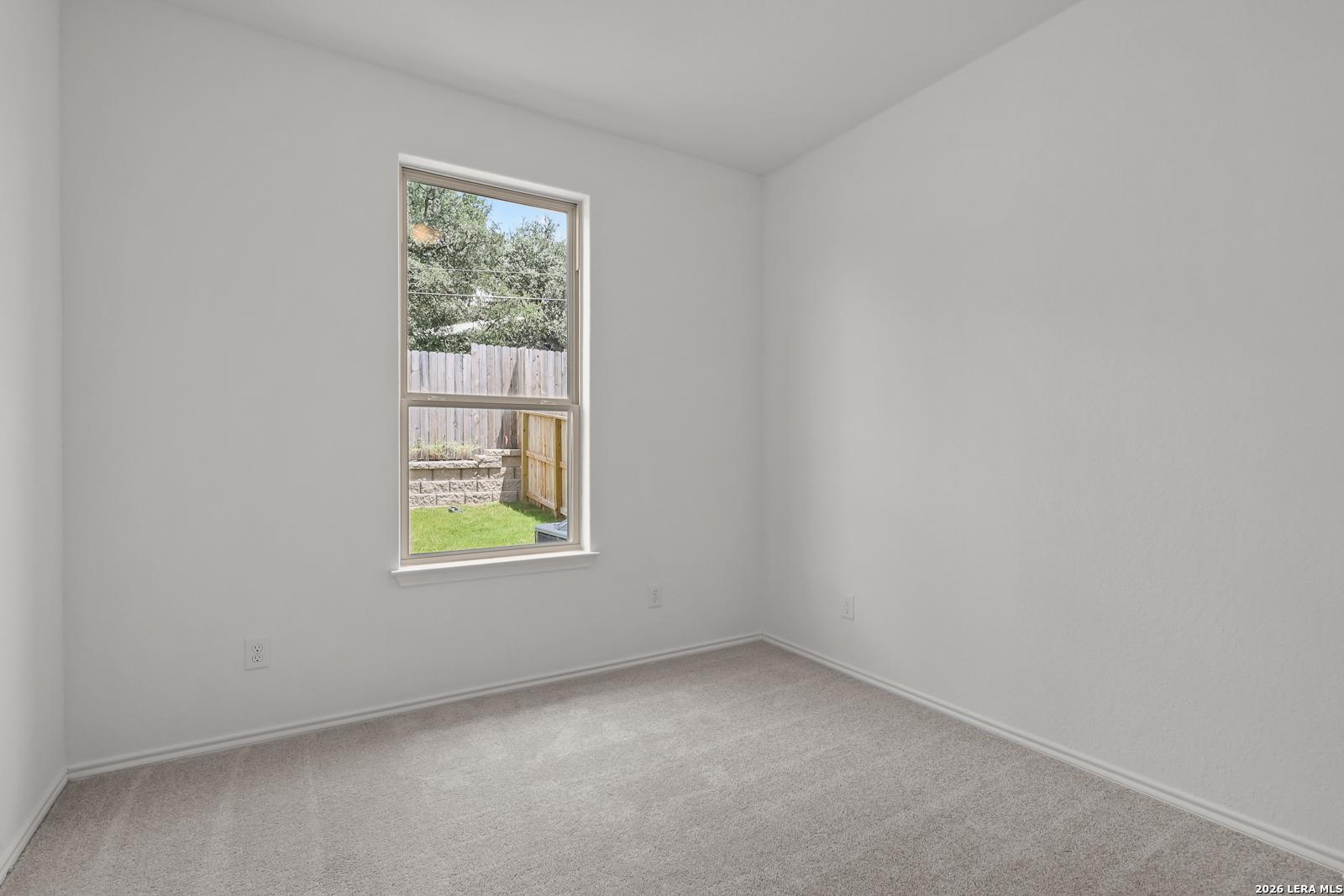 Bright bedroom with neutral carpet in The Gillian C floor plan at Meadows at Oak Creek, San Antonio, Texas.