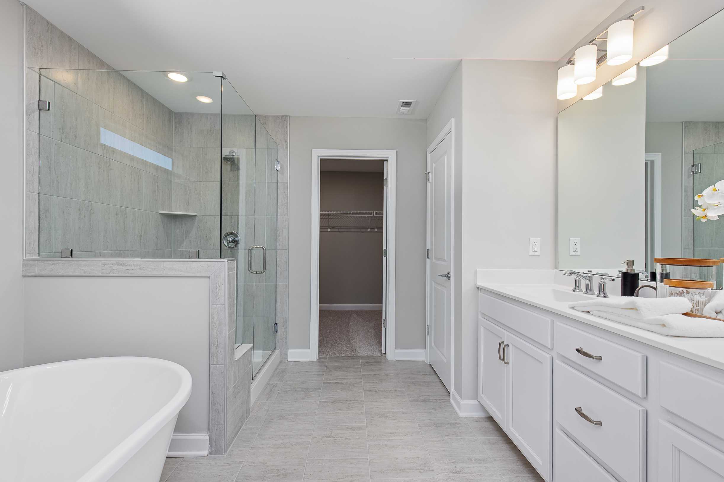 Modern master bathroom at Prince Place in Fuquay-Varina NC with freestanding tub, glass shower, double vanity