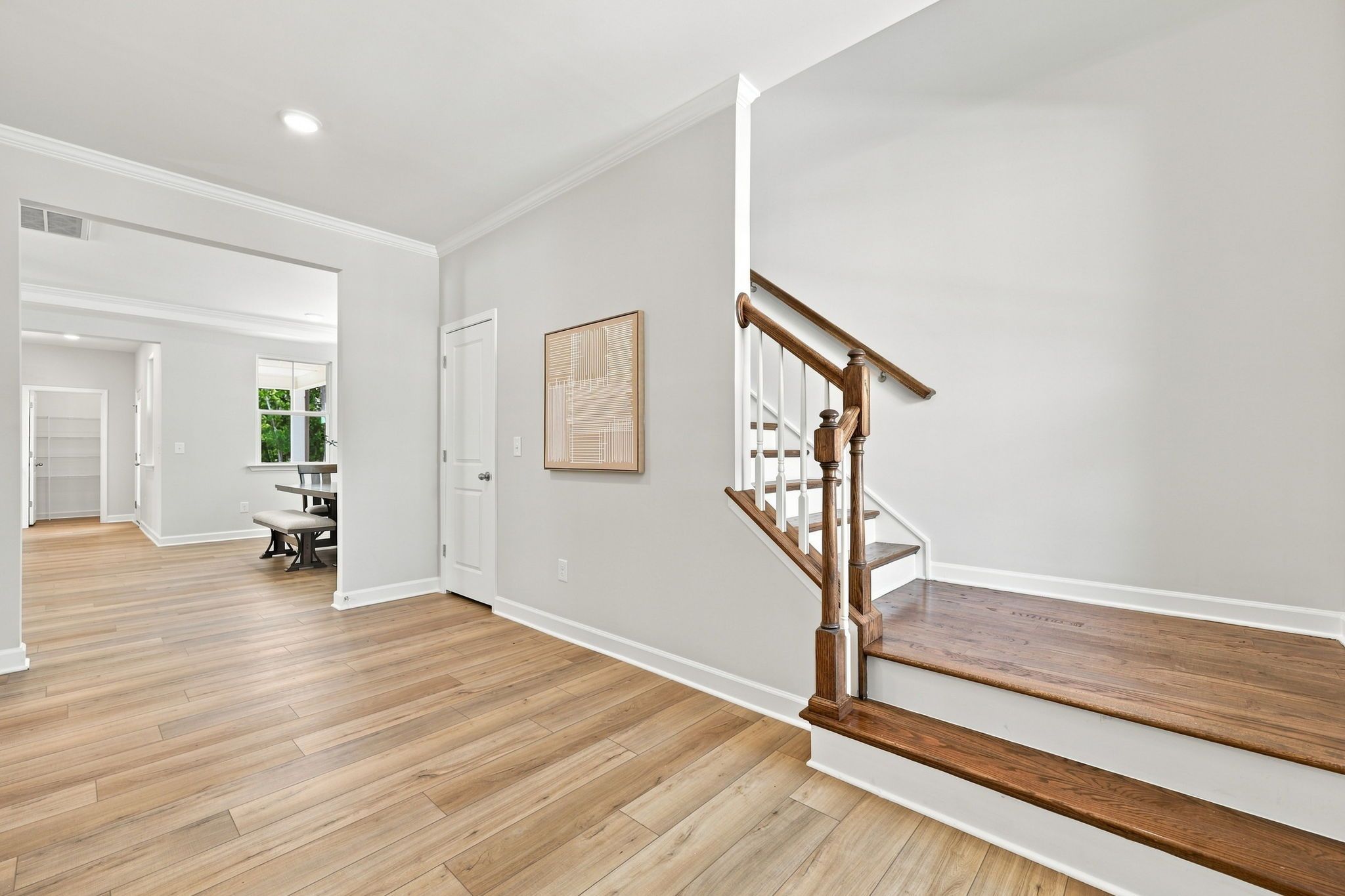Foyer entrance of The Jordan A in Knightdale, featuring hardwood floors, a staircase, and a view into the dining area.