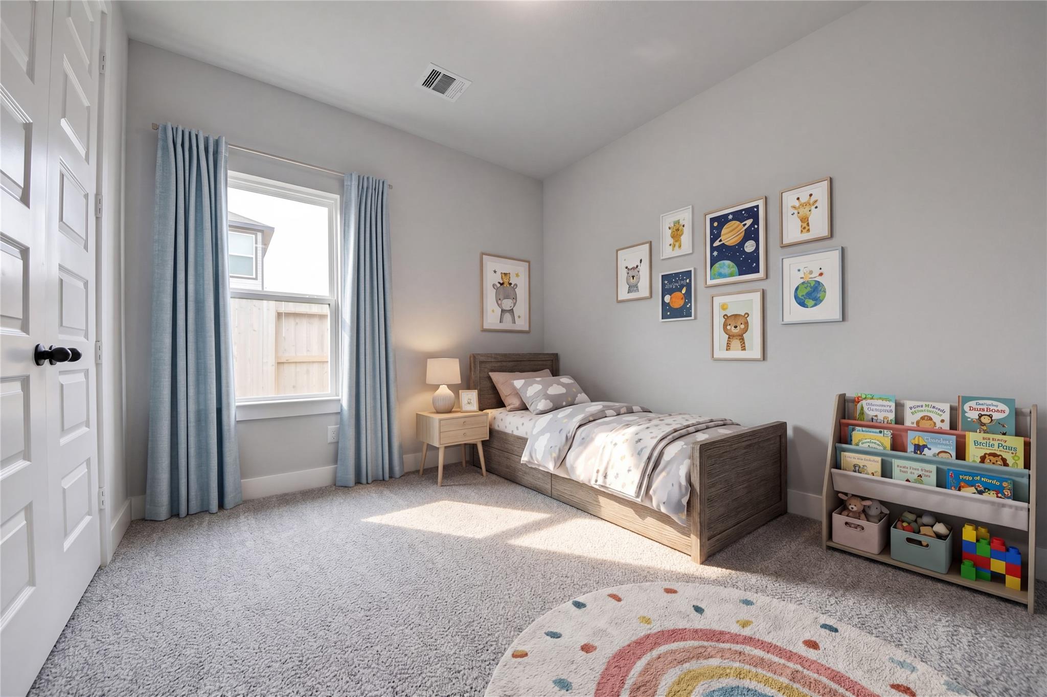 Bright bedroom with twin bed, gallery wall, and toy storage in Davidson Homes The Laguna C plan, Sunterra, Katy, TX