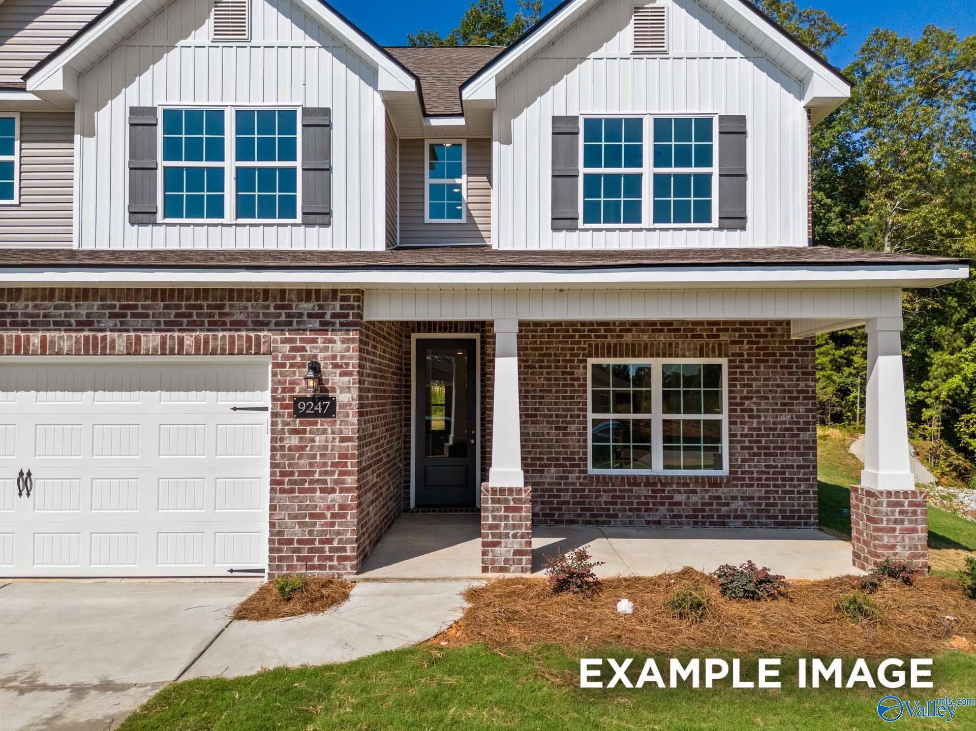 Two-story brick and siding home with two-car garage, covered porch, and lush landscaping in The Highlands, Arab, Alabama