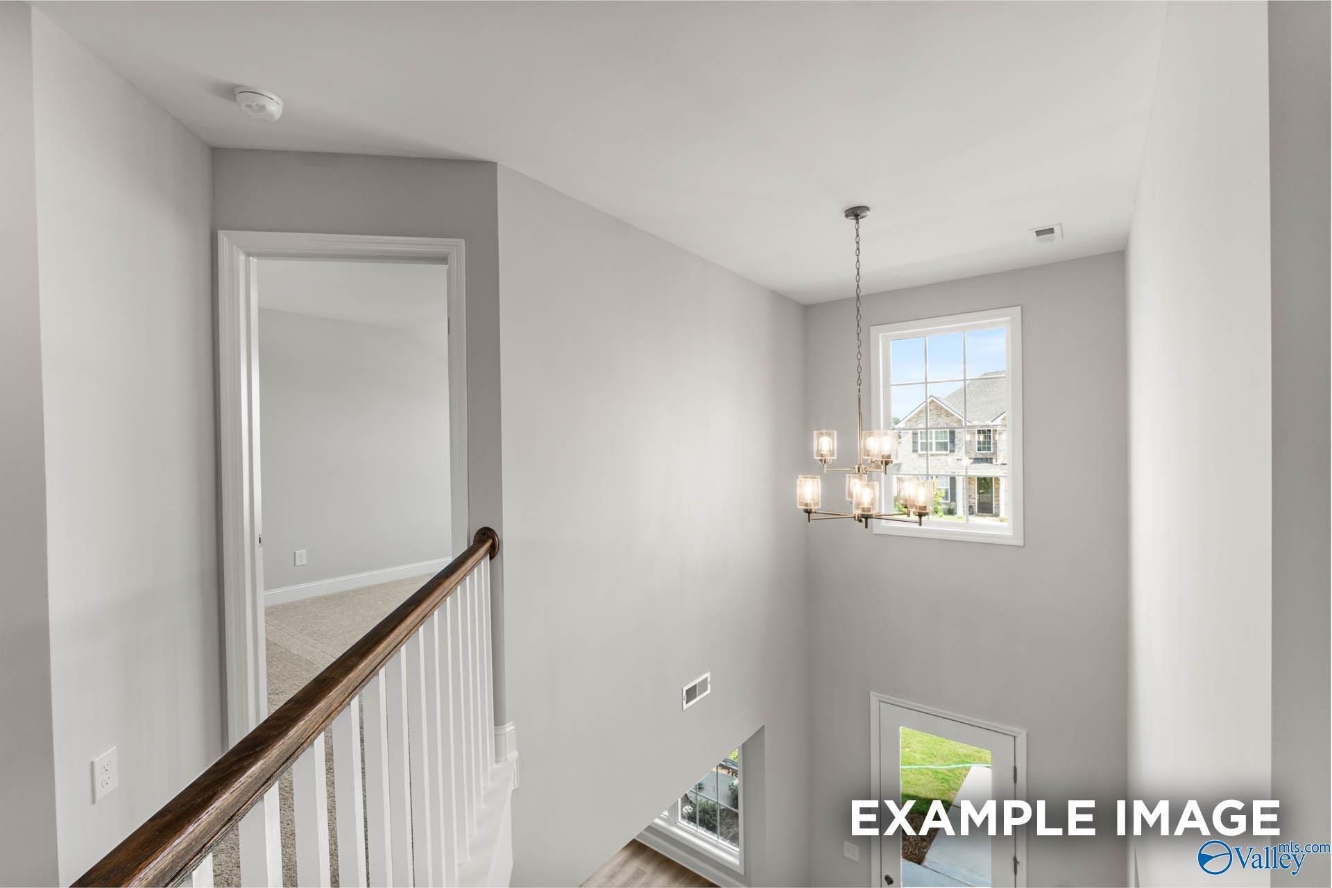 Two-story foyer with chandelier and open landing in The Madison A floor plan at The Meadows in Athens, Alabama.