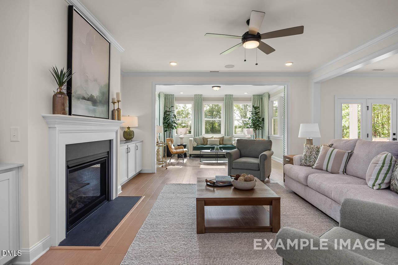 Cozy family room with gas fireplace, plush sofas, and large windows in Davidson Homes Crawford D, Tobacco Road, Angier, NC