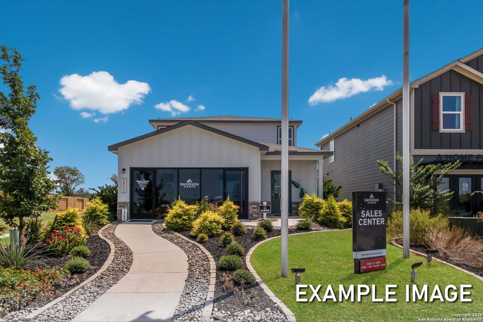 Modern two-story Sabine B home exterior with board-and-batten siding, landscaped yard, and sales center sign in Agave, San Antonio, Texas