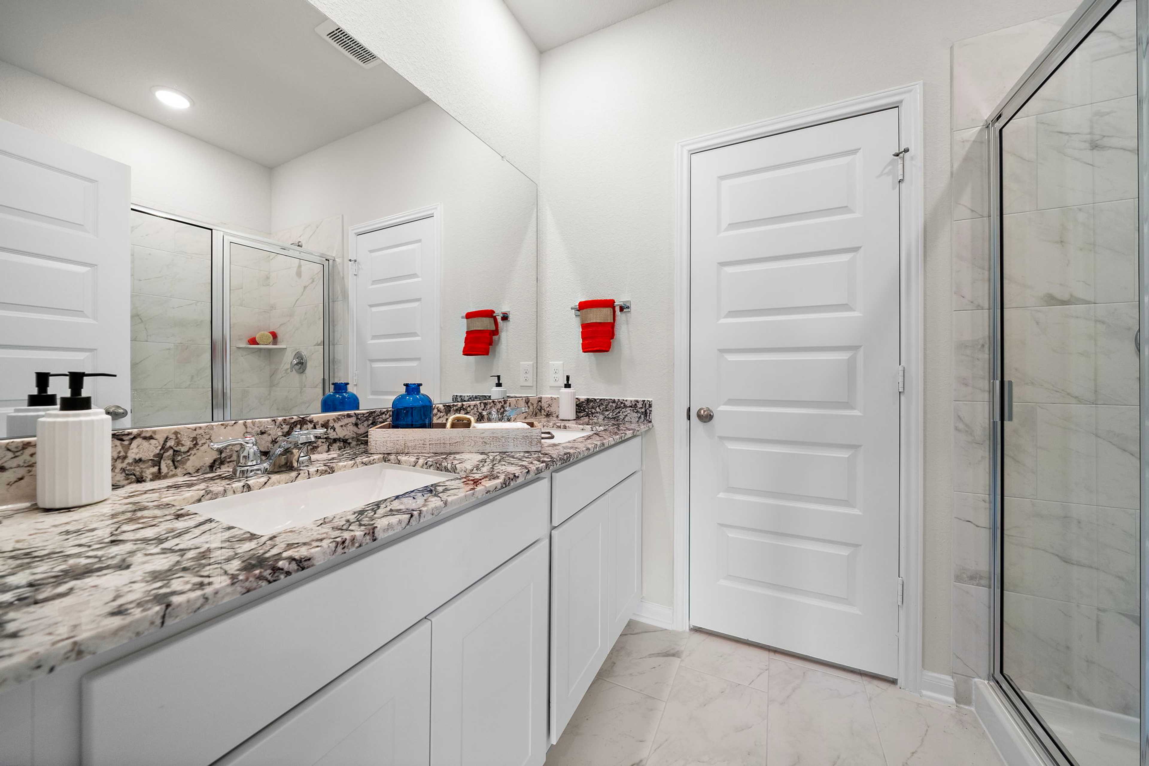 Modern bathroom with double vanity, marble countertop, walk-in glass shower at Liberty Estates in Cleveland TX by Davidson Homes