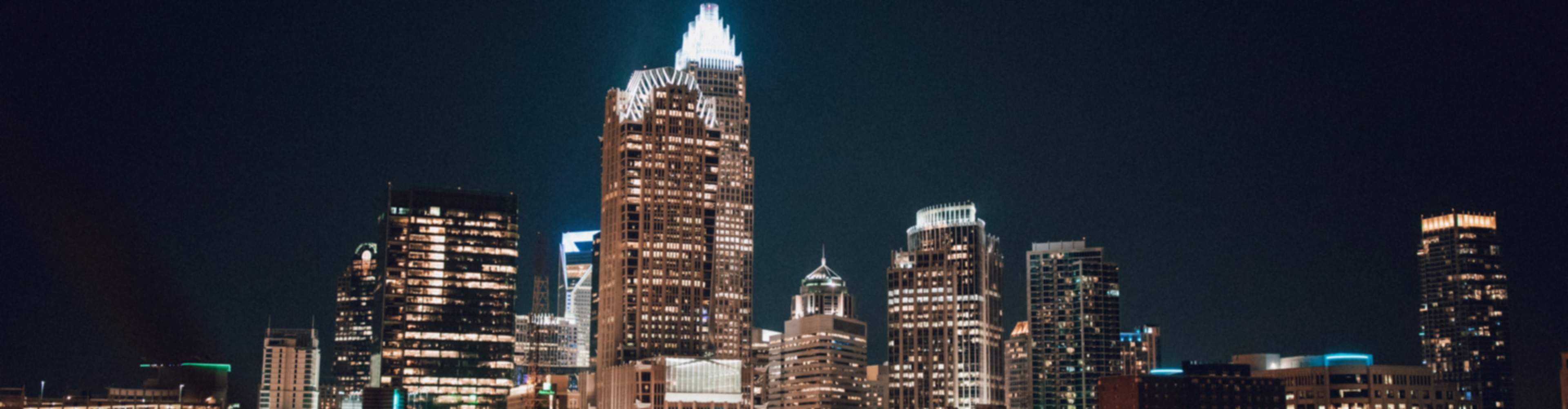 Vibrant Charlotte skyline at night with illuminated skyscrapers and city lights in the region