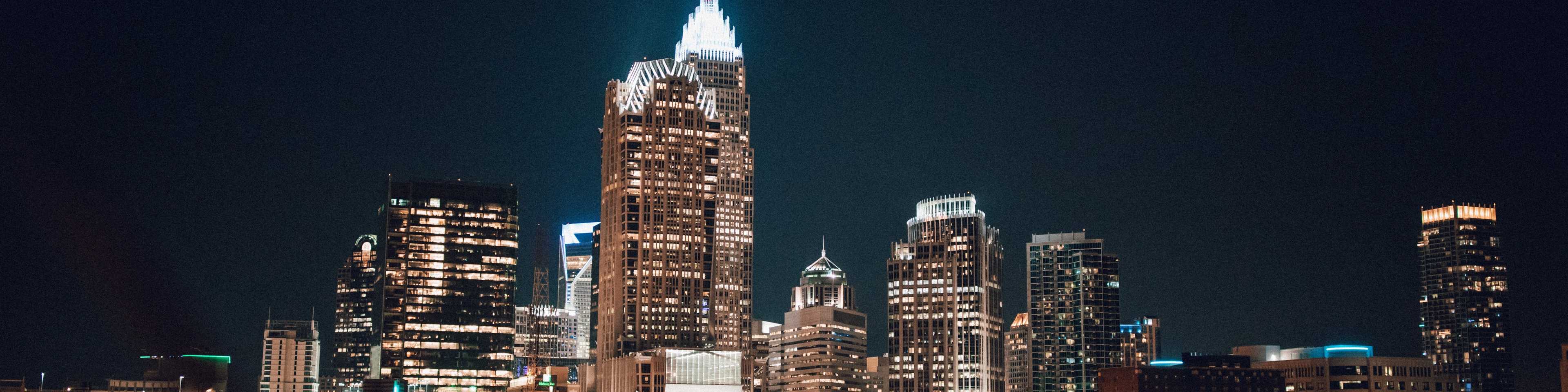 Vibrant Charlotte skyline at night with illuminated skyscrapers and city lights in the region