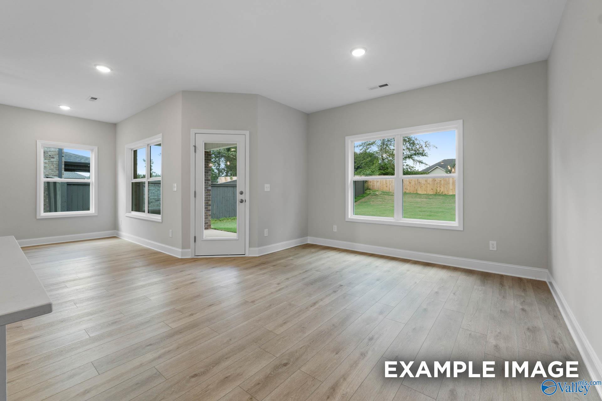 Bright family room with hardwood floors, large windows, and backyard view in 3-bedroom Davidson Homes The Franklin V, Athens, Alabama