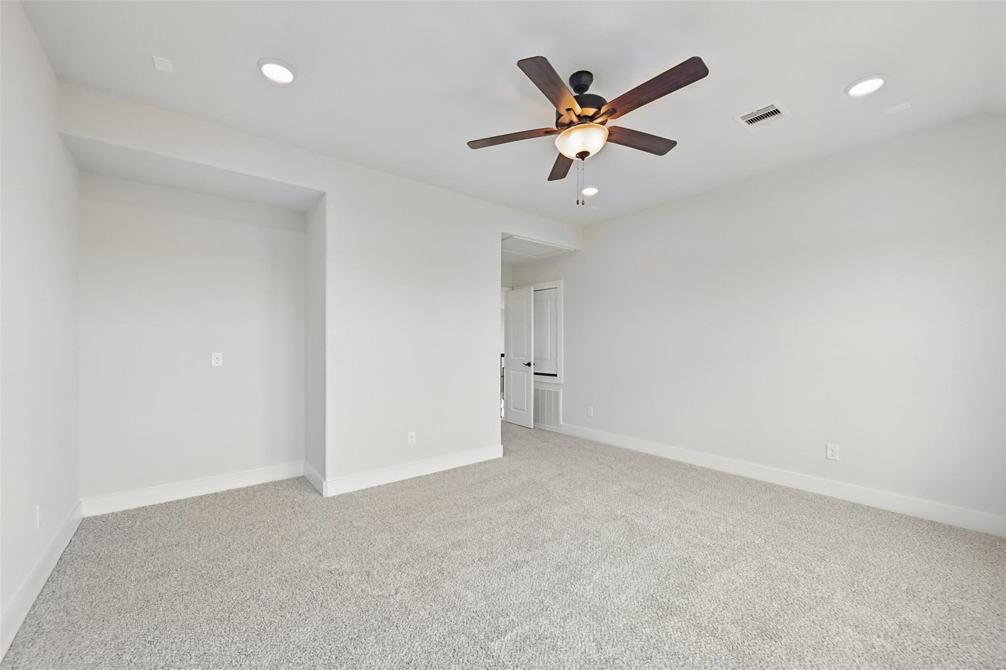 Bright secondary bedroom with ceiling fan, beige carpet, white walls in Davidson Homes The Victoria C, Lago Mar, Texas City