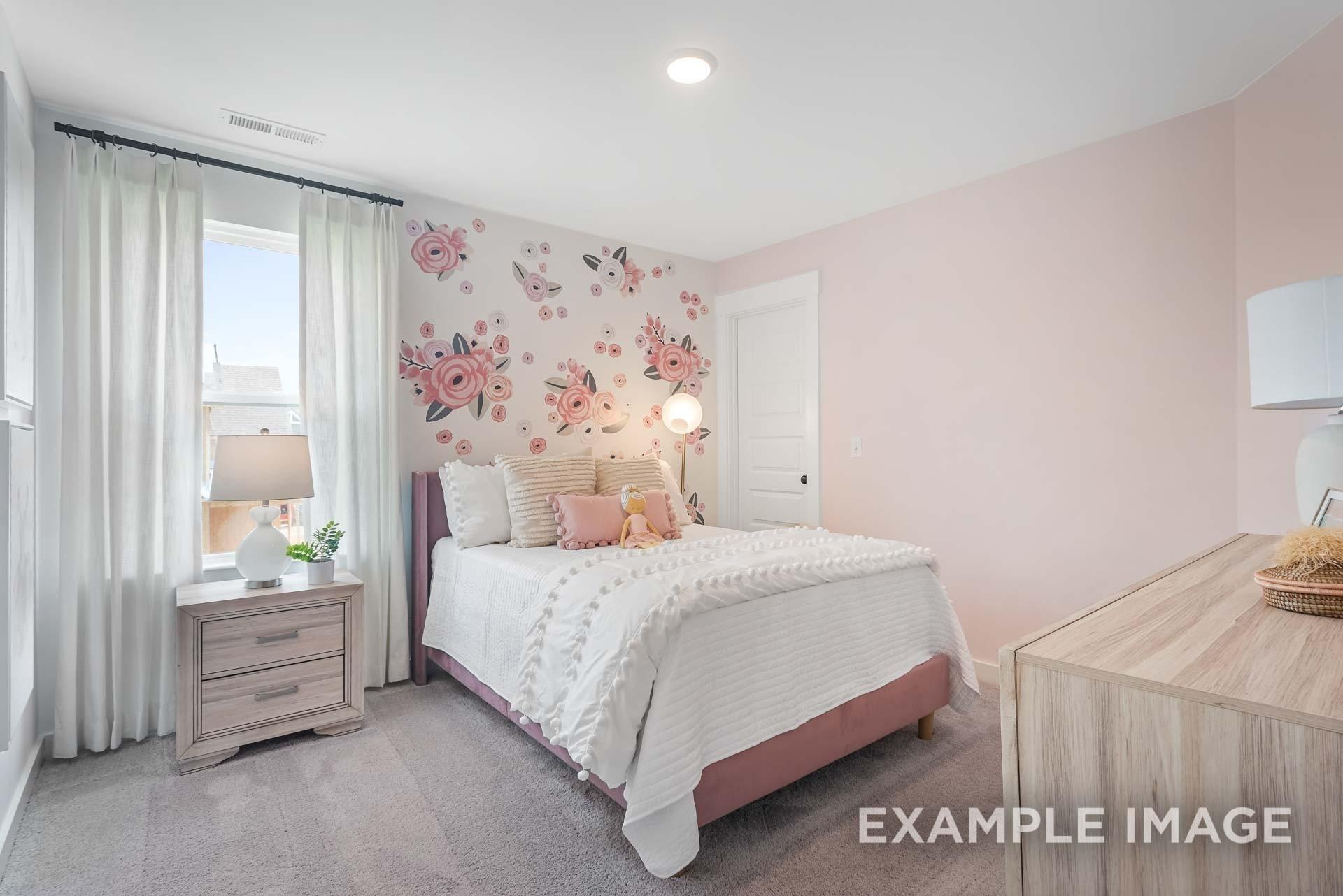 Charming girl's bedroom featuring pink floral accent wall, plush bed with white duvet, lamps, and dresser in 5-bedroom Davidson Homes The Ridgeport C, Gallatin, TN