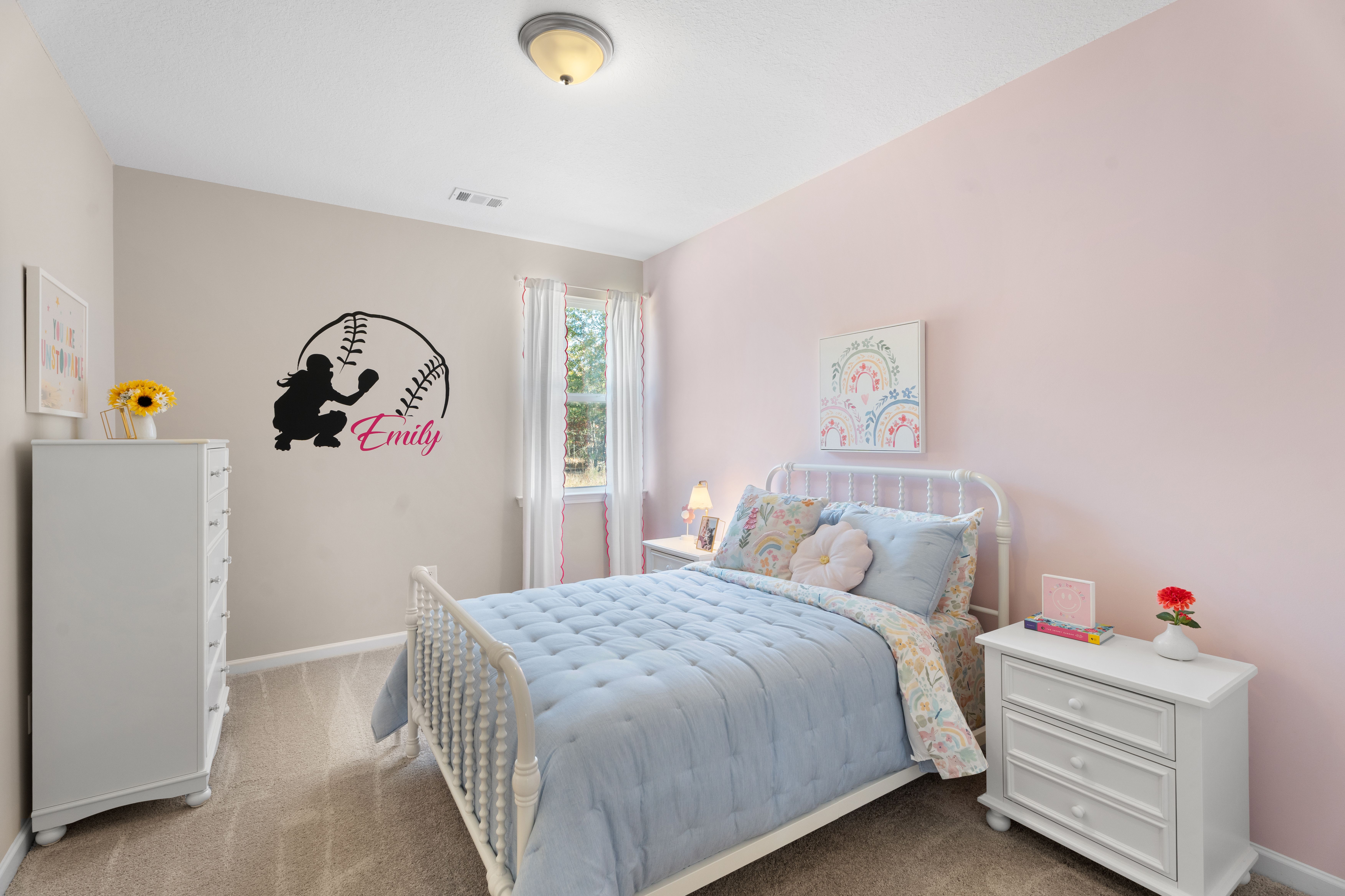 Baseball-themed girl's bedroom at Silver Oak in Cusseta Alabama by Evermore Homes with pink walls, white bed, and Emily bat silhouette