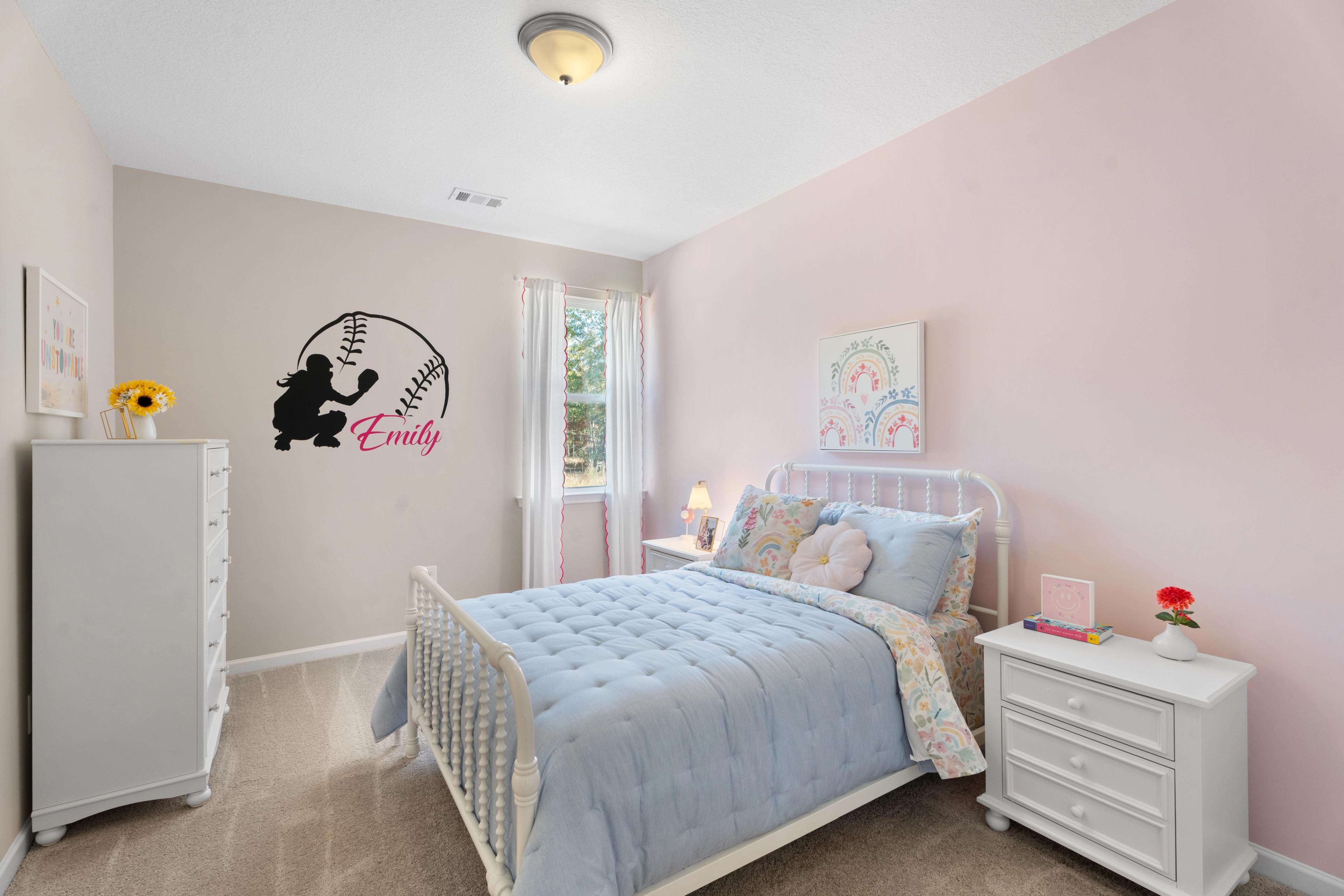 Baseball-themed girl's bedroom at Silver Oak in Cusseta Alabama by Evermore Homes with pink walls, white bed, and Emily bat silhouette