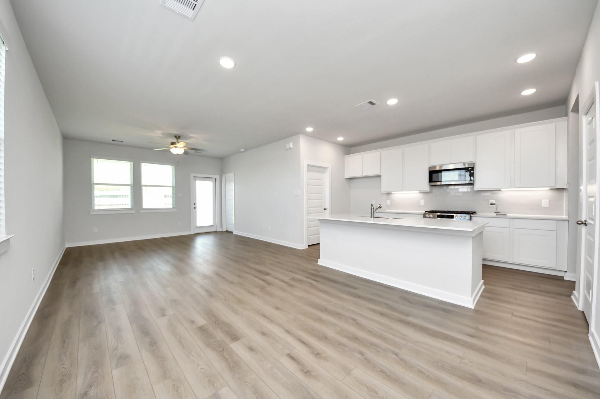 Open-concept kitchen and living area in The Costa A floor plan by Davidson Homes at Emberly in Beasley, Texas.