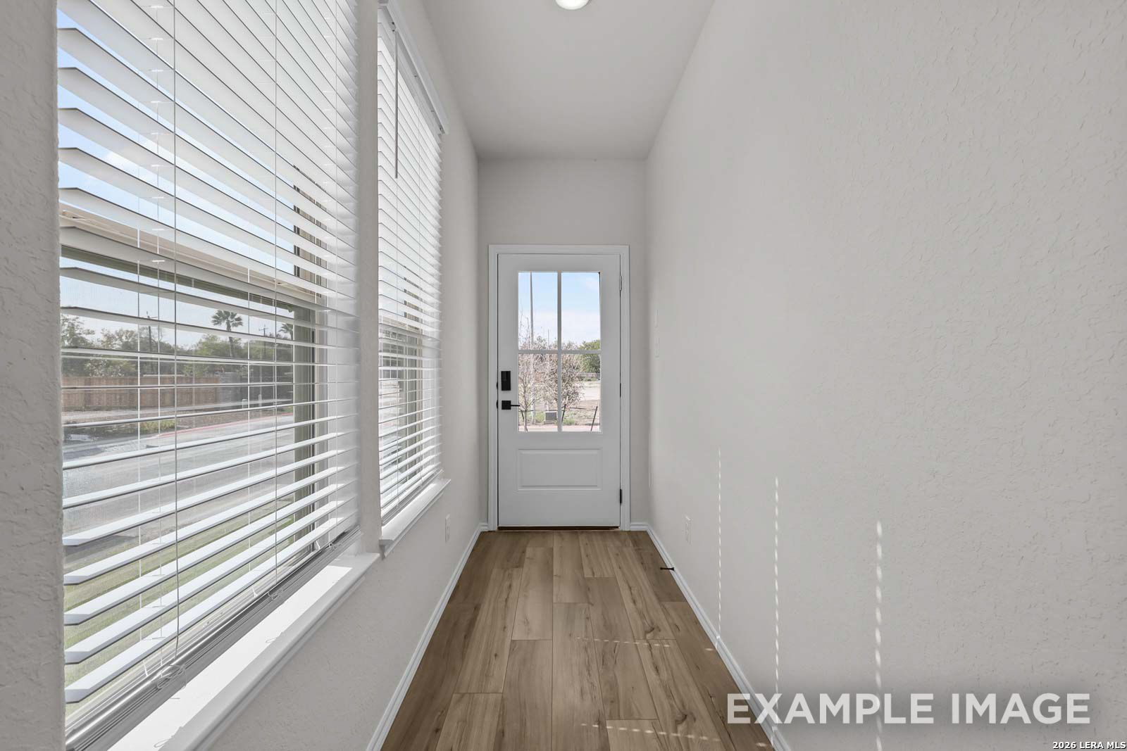 Bright entryway with wood-look flooring and natural light in The Florence A floor plan by Davidson Homes, San Antonio.