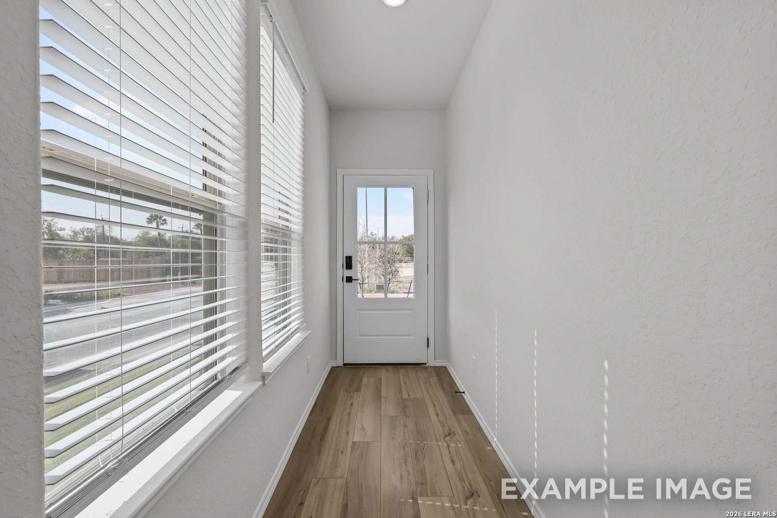 Bright entryway with wood-look flooring and natural light in The Florence D floor plan by Davidson Homes, San Antonio.