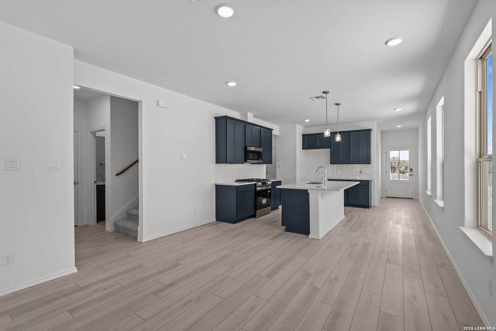 Modern kitchen with navy cabinets and white island in The Gillian C floor plan at Meadows at Oak Creek, San Antonio, Texas.