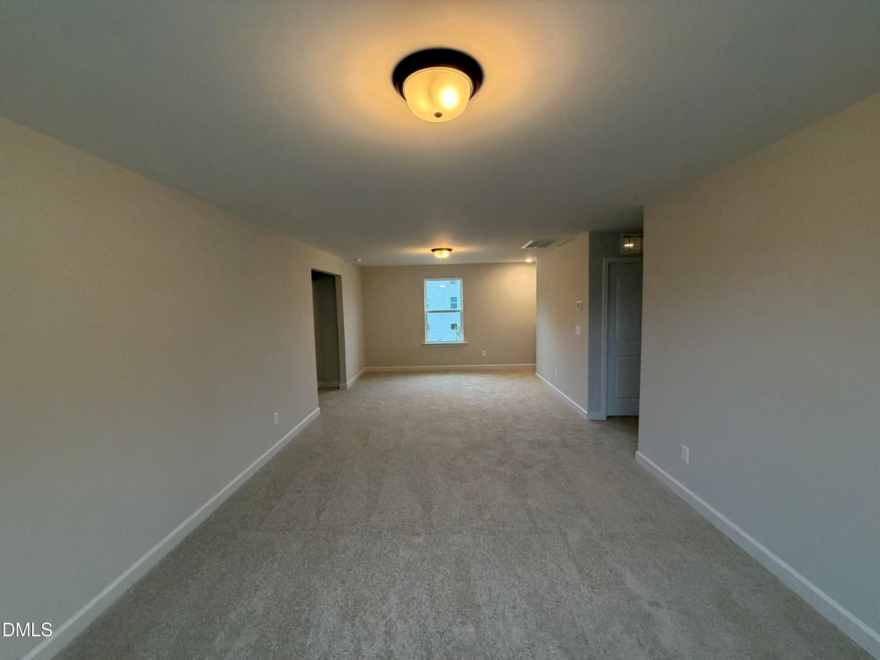Spacious carpeted bonus room with neutral walls and natural light in Davidson Homes The Preston C, Wendell Ridge, NC