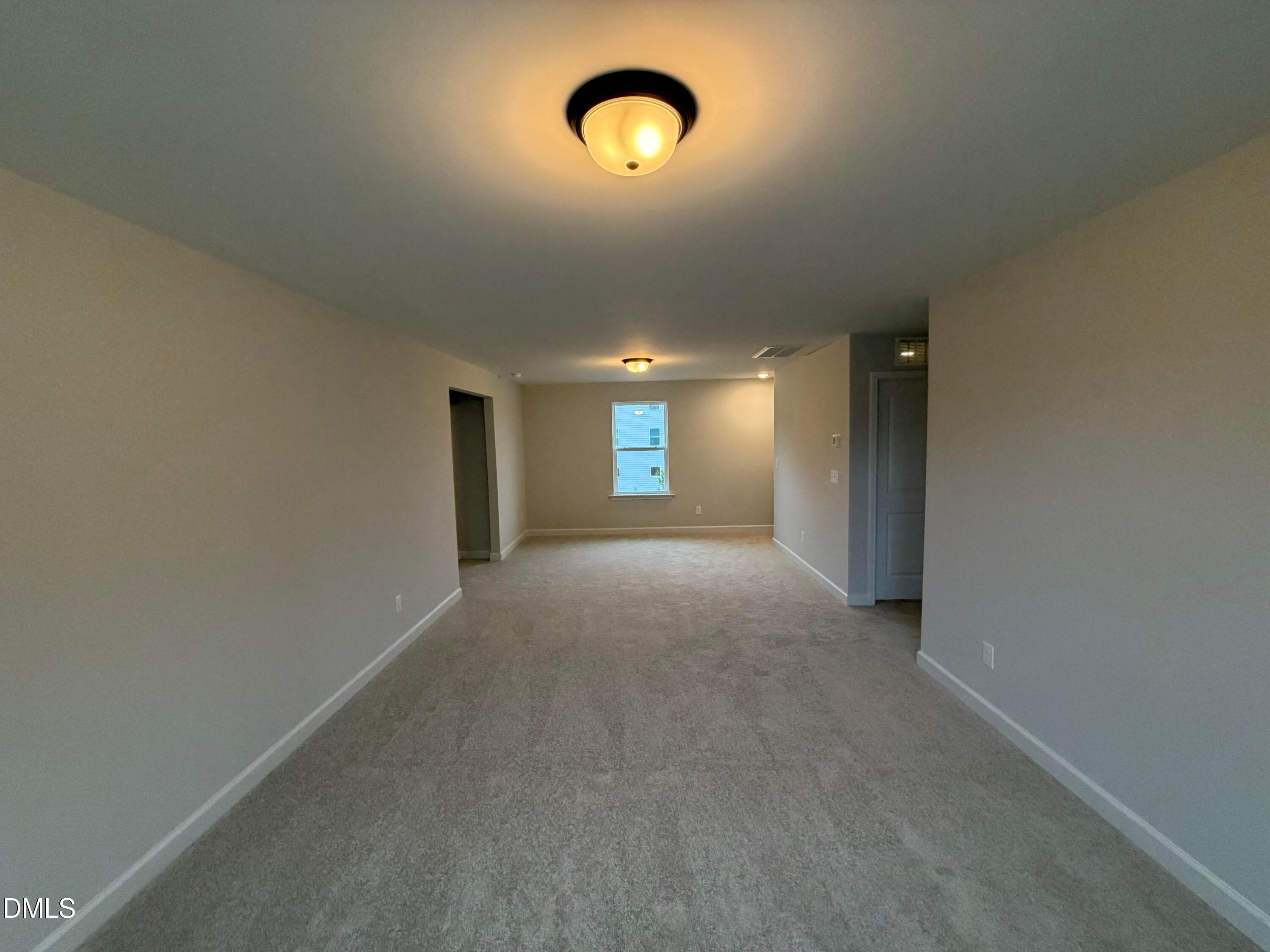 Spacious carpeted bonus room with neutral walls and natural light in Davidson Homes The Preston C, Wendell Ridge, NC