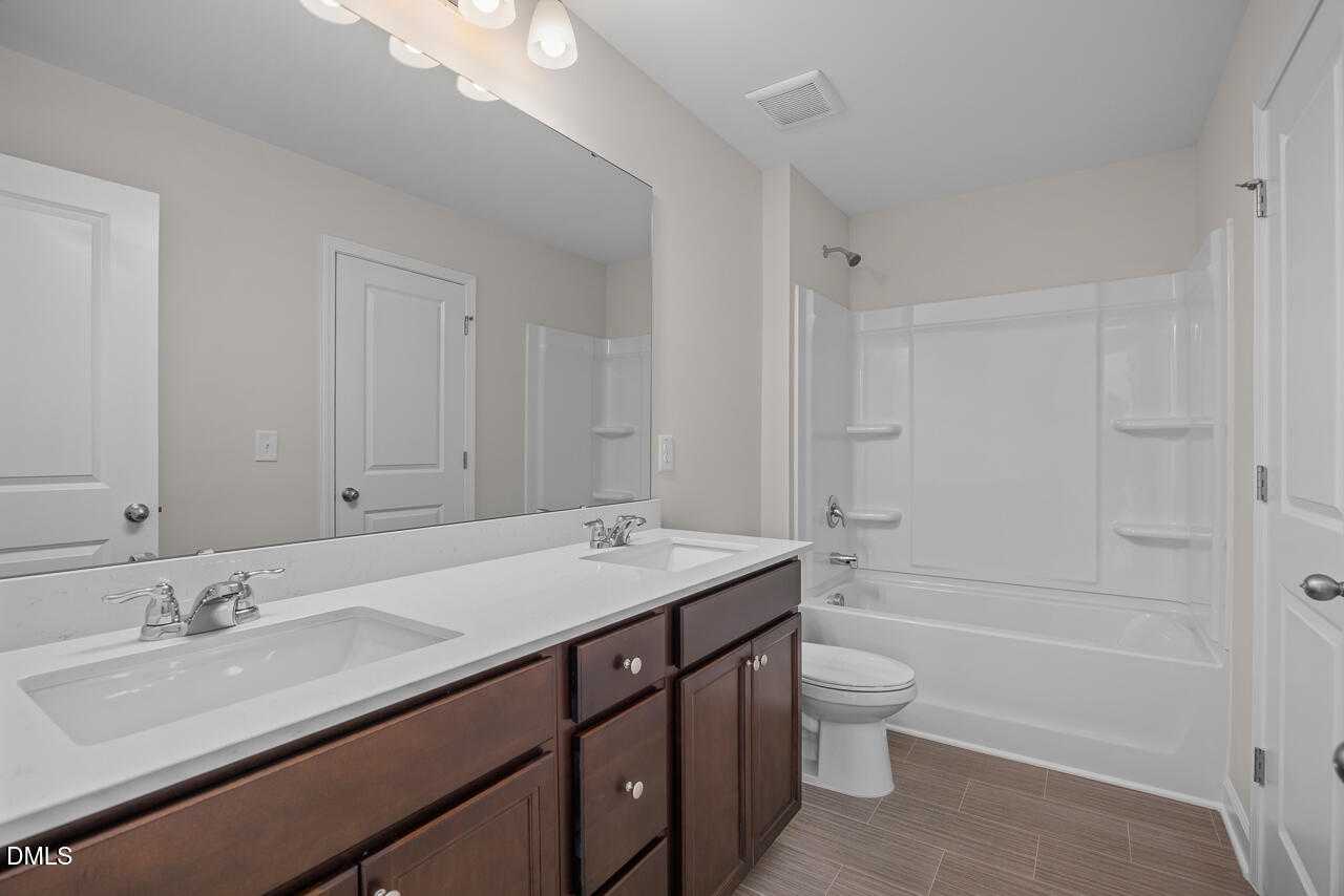 Modern double vanity bathroom with bathtub shower combo in The Gavin C 3-bedroom home, Davidson Homes, Lillington, NC