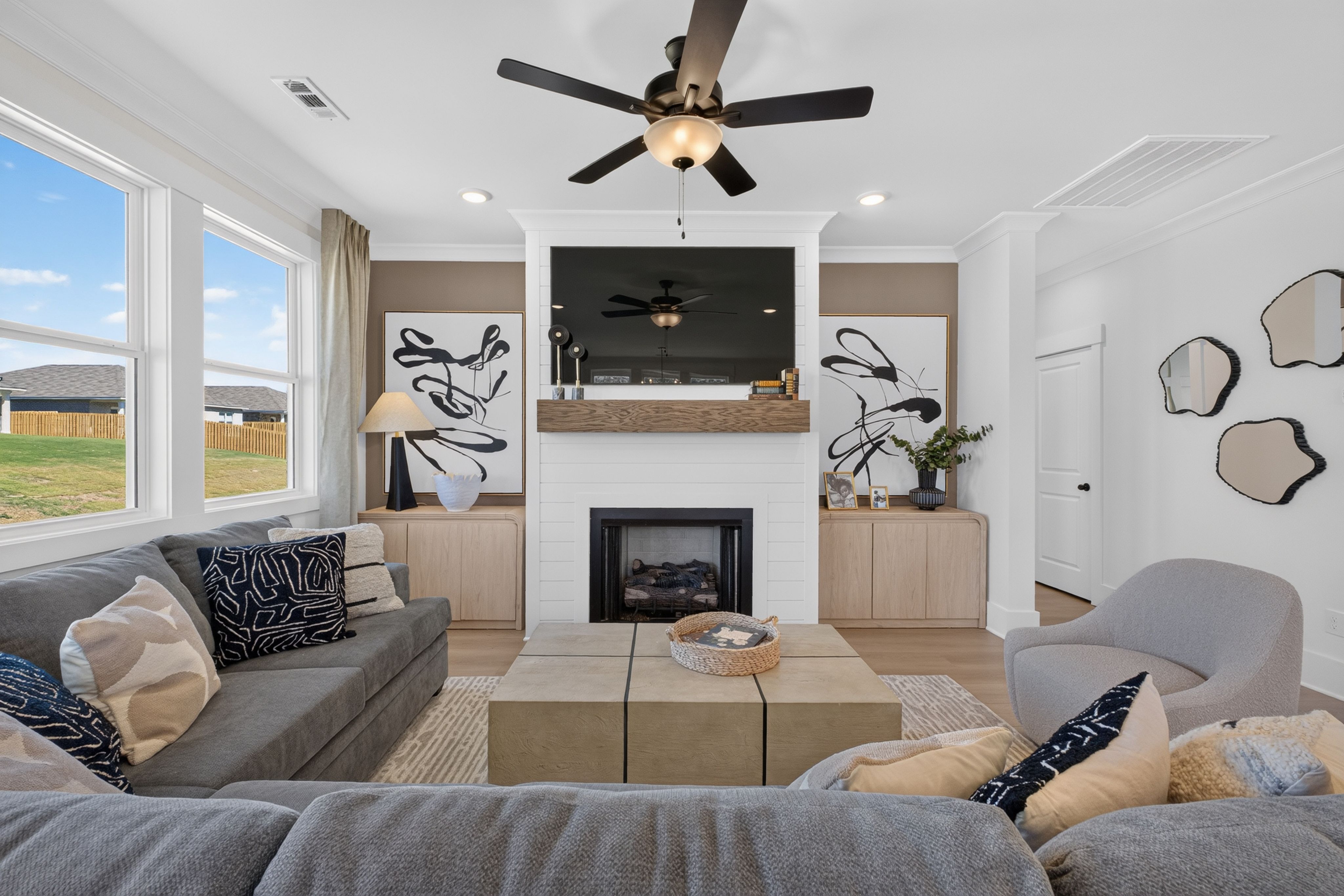 Bright great room with fireplace, shiplap surround, and large windows at Evergreen Mill by Davidson Homes in Madison, Alabama