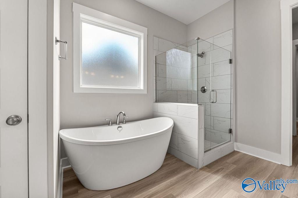 Luxurious master bathroom with freestanding tub and glass walk-in shower in Evermore Homes The Oxford, Owens Cross Roads, AL