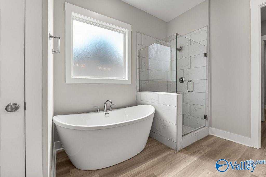 Luxurious master bathroom with freestanding tub and glass walk-in shower in Evermore Homes The Oxford, Owens Cross Roads, AL