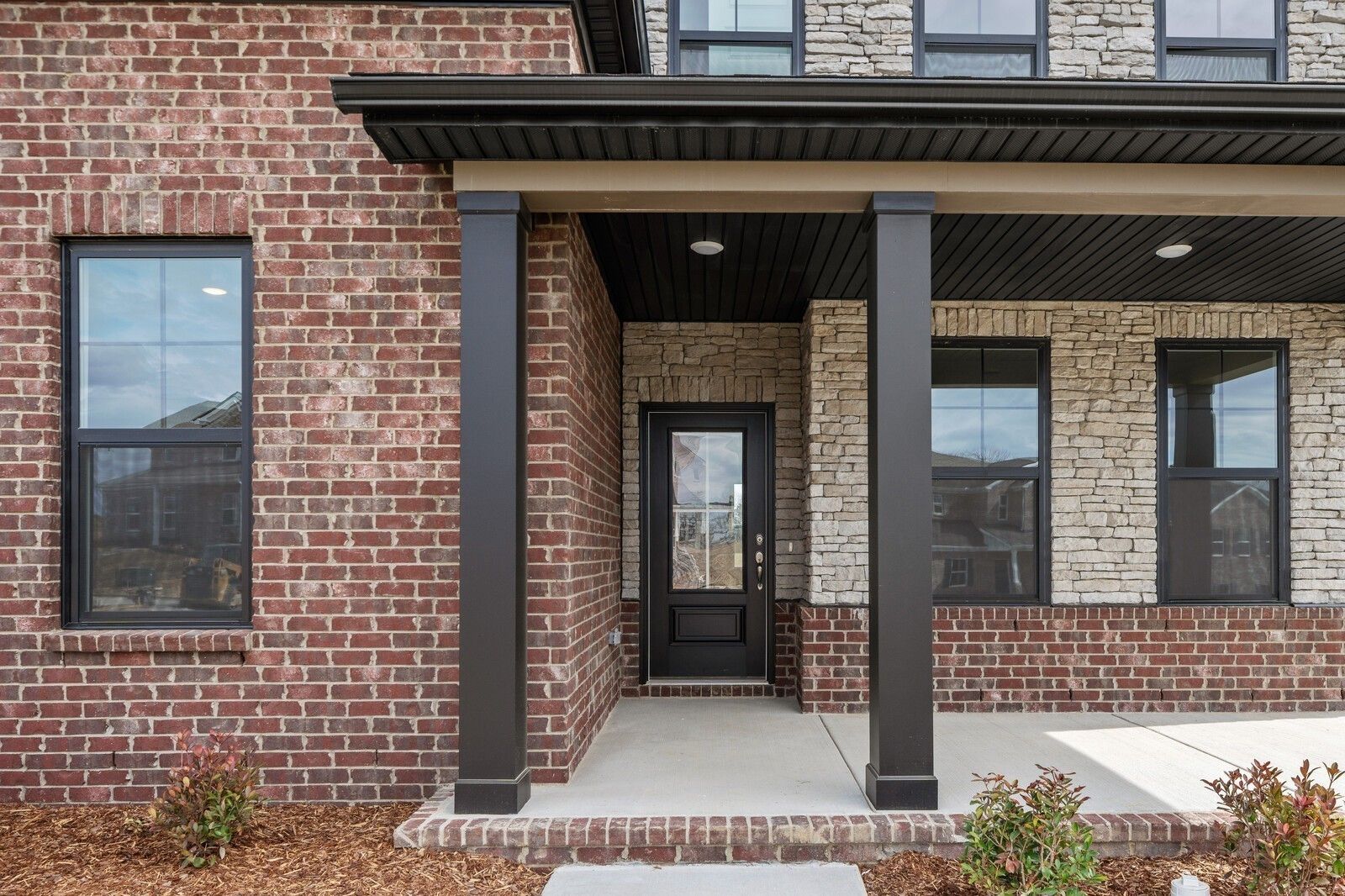 Covered front porch with brick and stone facade on The Henry C floor plan by Davidson Homes in Mt. Juliet, Tennessee.