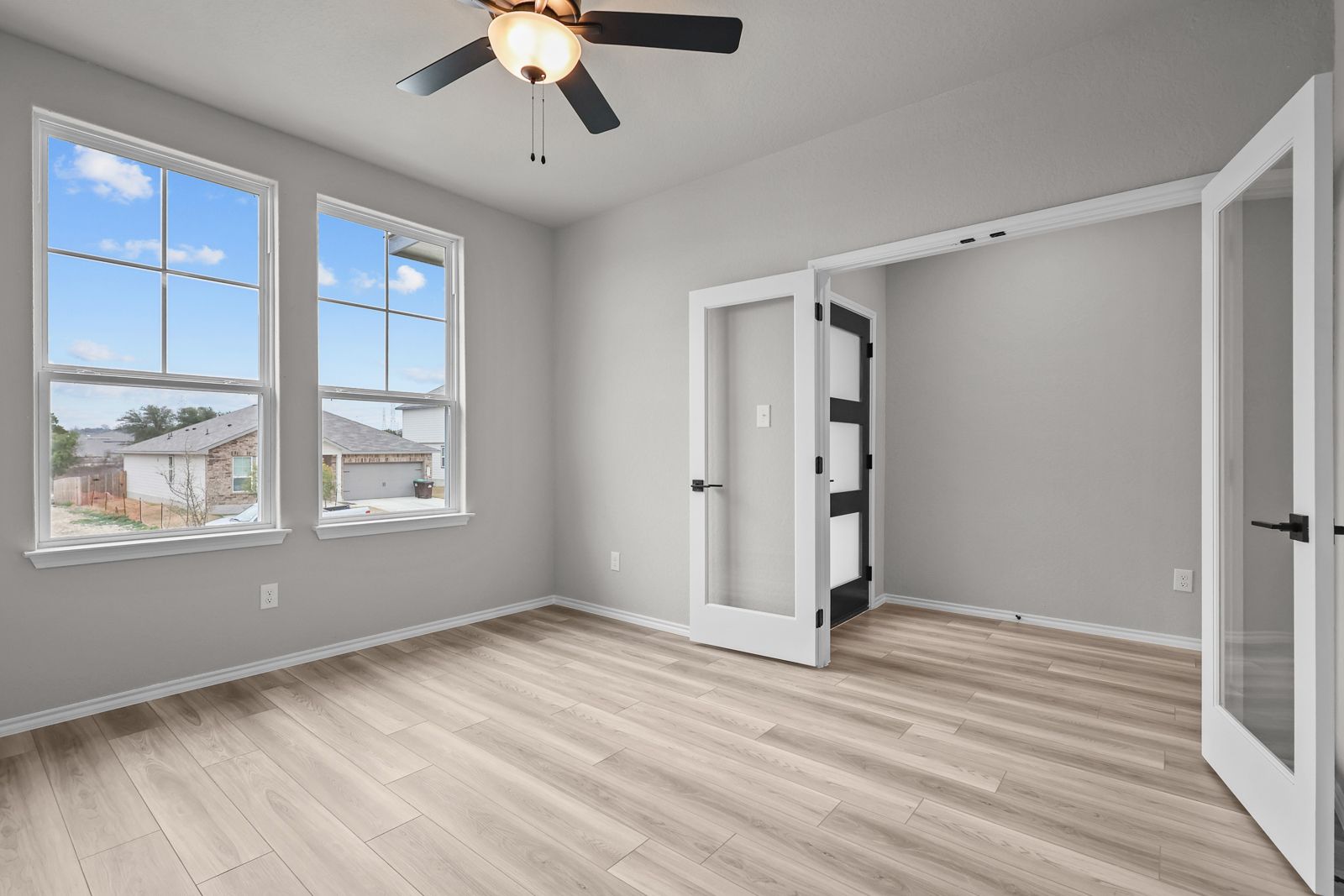 Flexible flex room with French doors and wood-look flooring in The Glenwood home design by Davidson Homes.