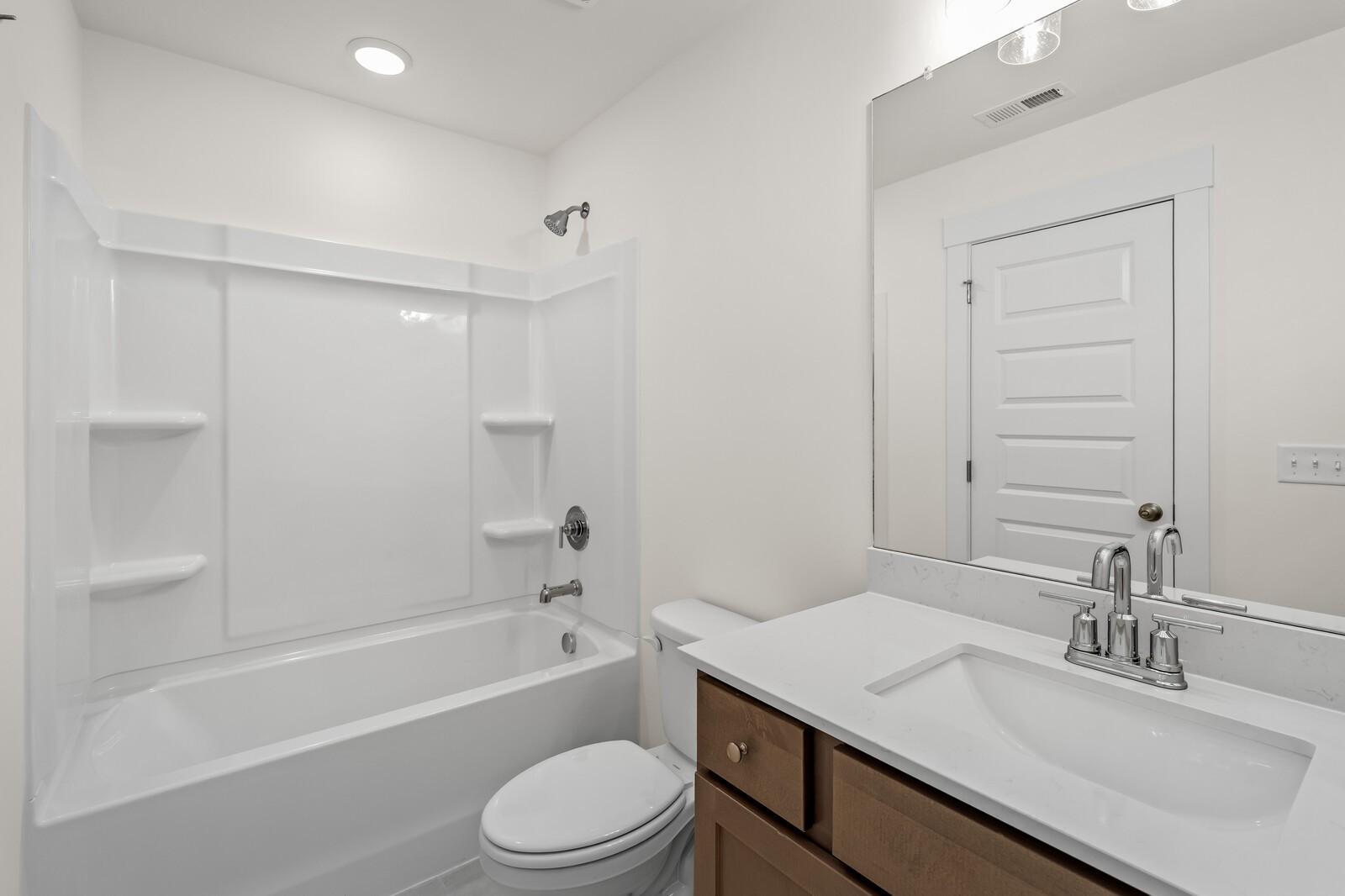 Modern full bathroom with tub-shower combo and vanity in The Henry C floor plan at Benders Cove, Mt. Juliet, Tennessee.