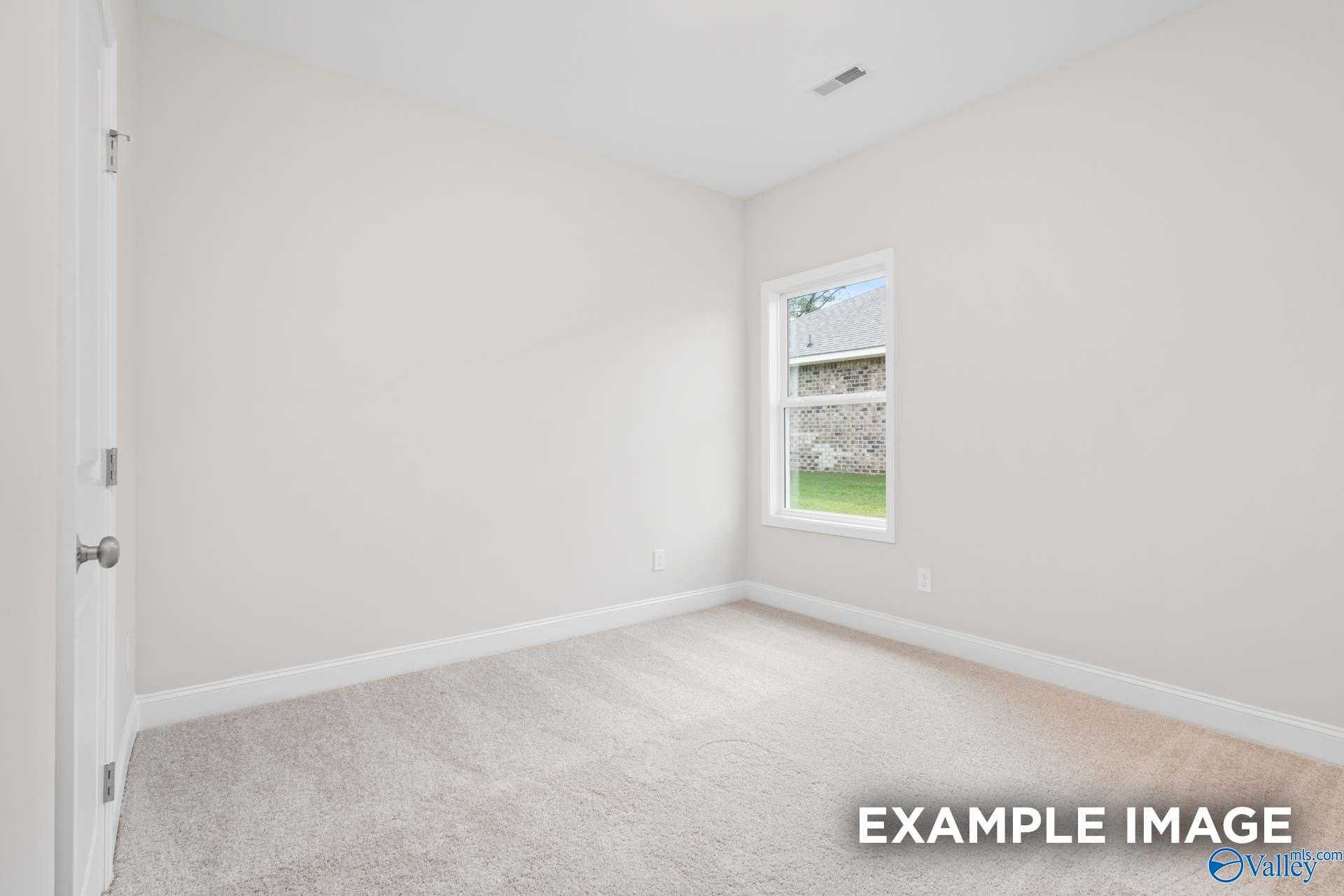 Bright secondary bedroom with large window overlooking green yard in Davidson Homes The Franklin, Meridianville, Alabama