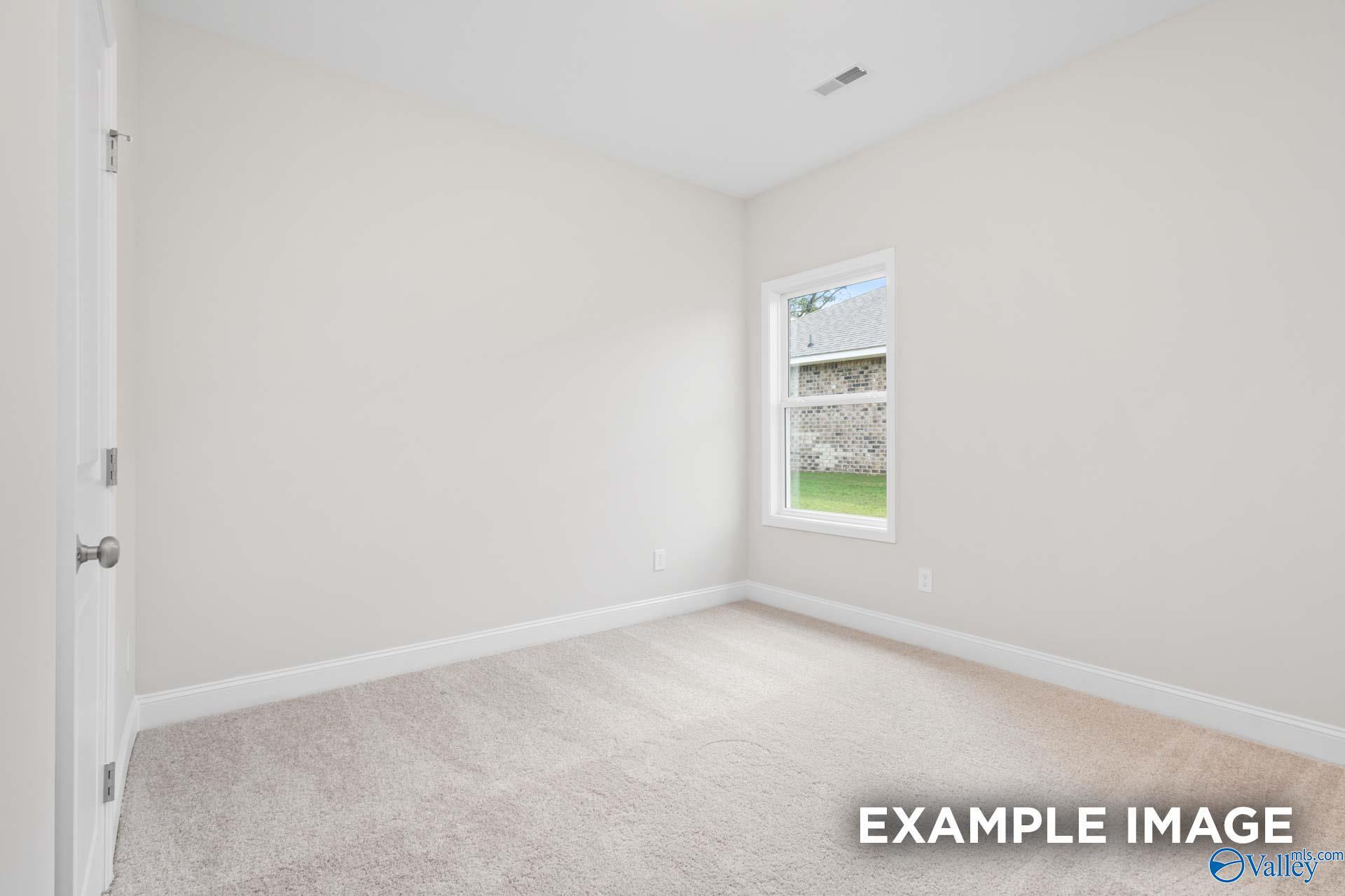 Bright secondary bedroom with large window overlooking green yard in Davidson Homes The Franklin, Meridianville, Alabama