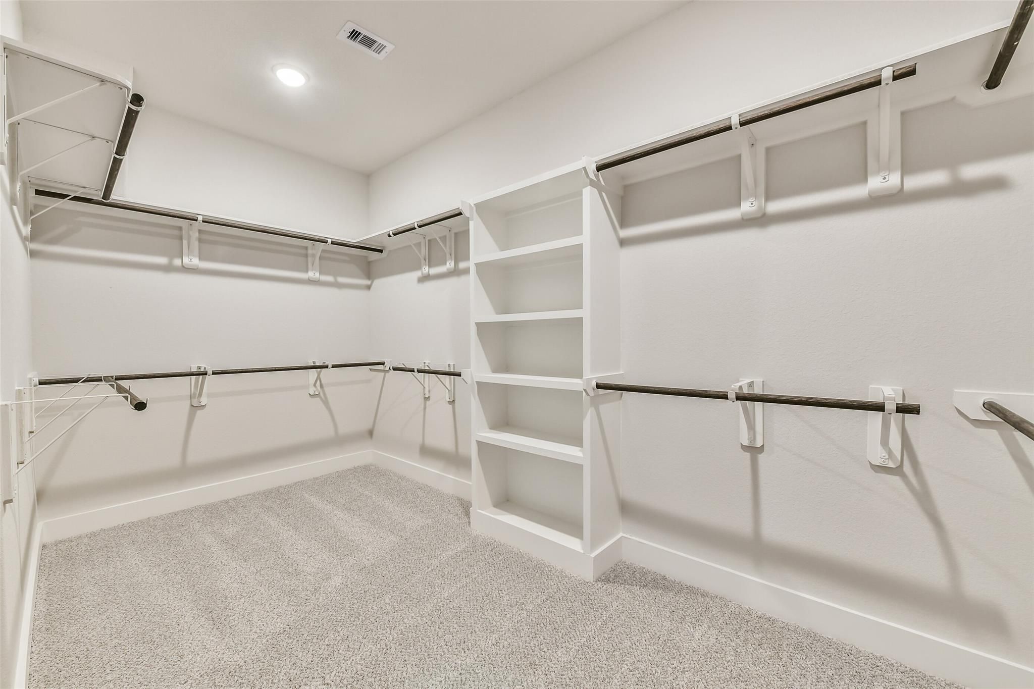 Spacious walk-in closet with built-in shelves and hanging rods in Davidson Homes The George A, Lago Mar, Texas City