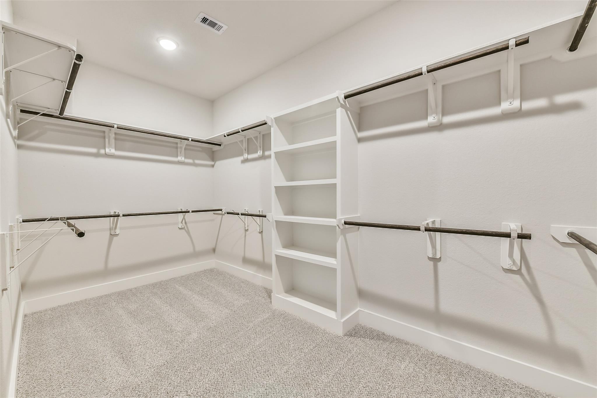 Spacious walk-in closet with built-in shelves and hanging rods in Davidson Homes The George A, Lago Mar, Texas City