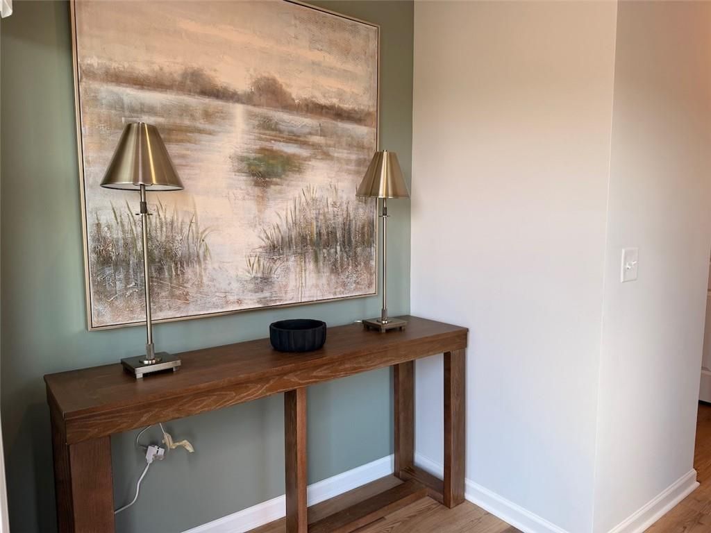 Wood console table with lamps and landscape art in foyer of Davidson Homes Pinecrest J in Greene Farm, Cartersville, Georgia