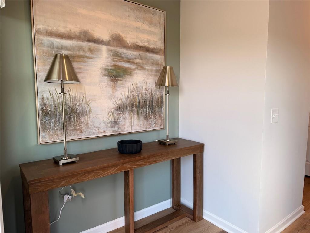 Wood console table with lamps and landscape art in foyer of Davidson Homes Pinecrest J in Greene Farm, Cartersville, Georgia