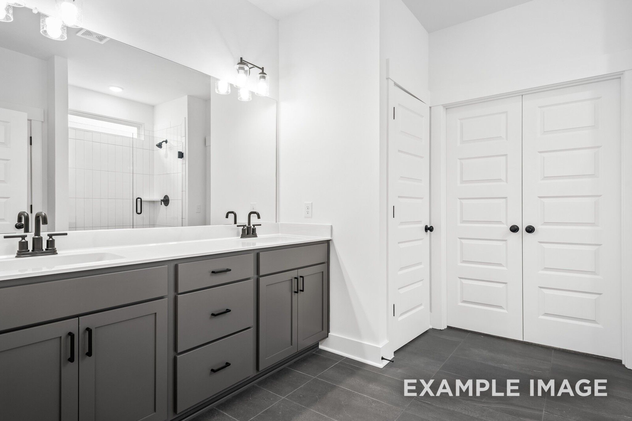 Modern master bathroom featuring double gray vanity, dual sinks, and large mirrors in Davidson Homes Ridgeport C, Gallatin, TN
