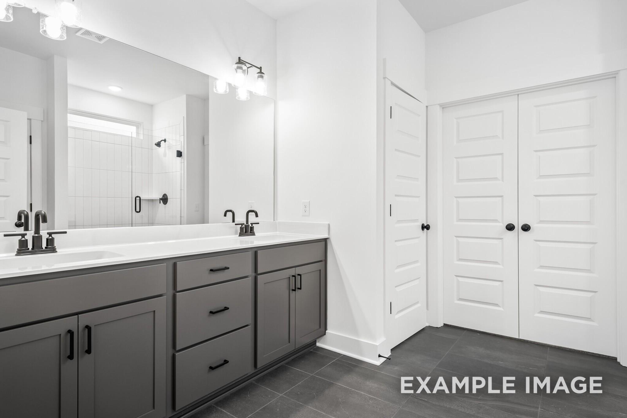 Modern master bathroom featuring double gray vanity, dual sinks, and large mirrors in Davidson Homes Ridgeport C, Gallatin, TN