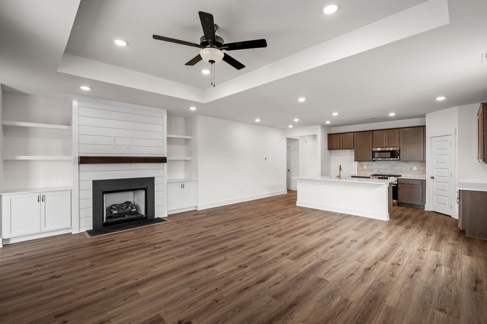 Open-concept living room with fireplace and modern kitchen in The Prairie C floor plan at Woods Crossing, Gallatin, TN.