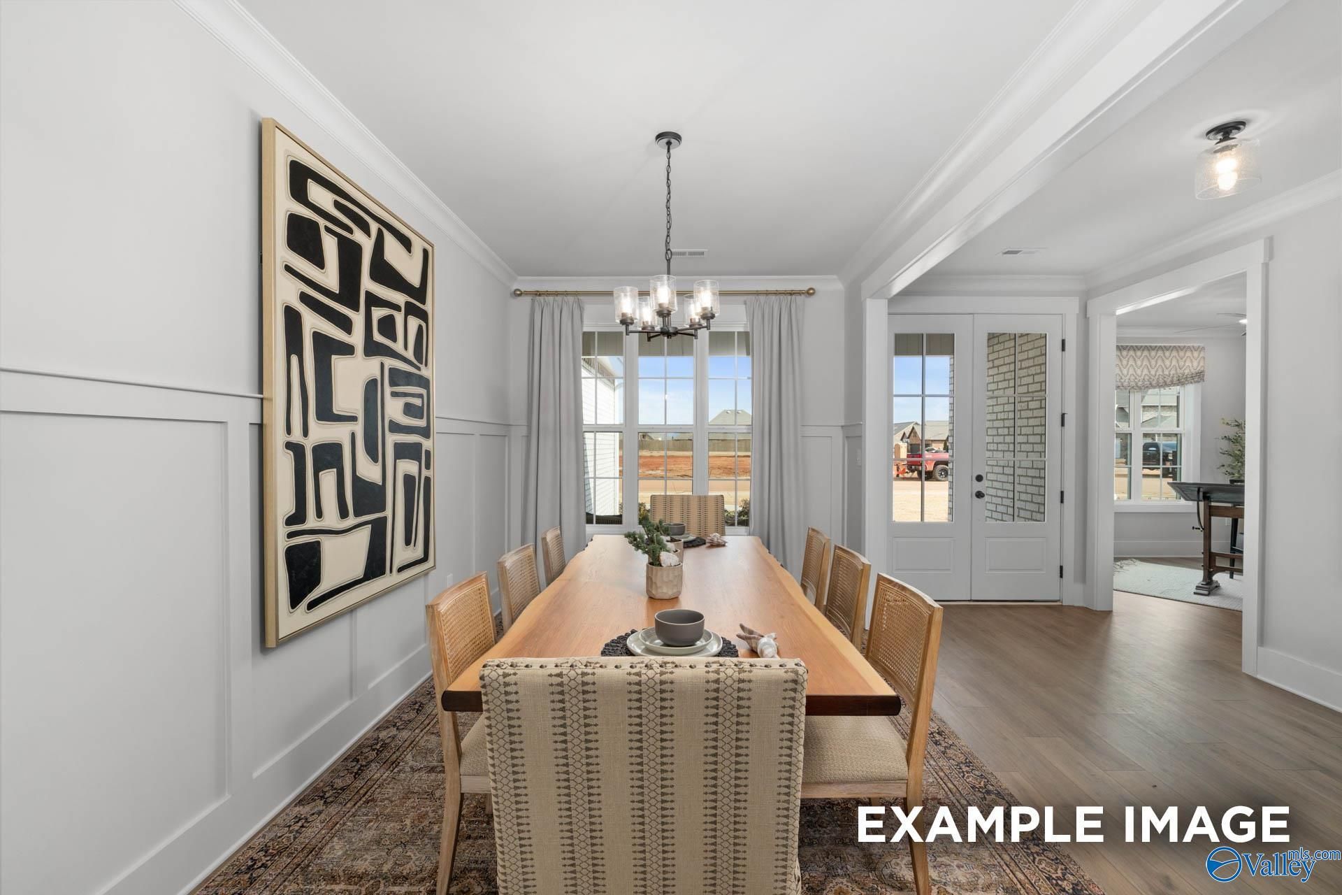 Elegant dining room featuring wooden table, upholstered chairs, chandelier, and abstract art in The Finleigh 5-bedroom home, Decatur, Alabama