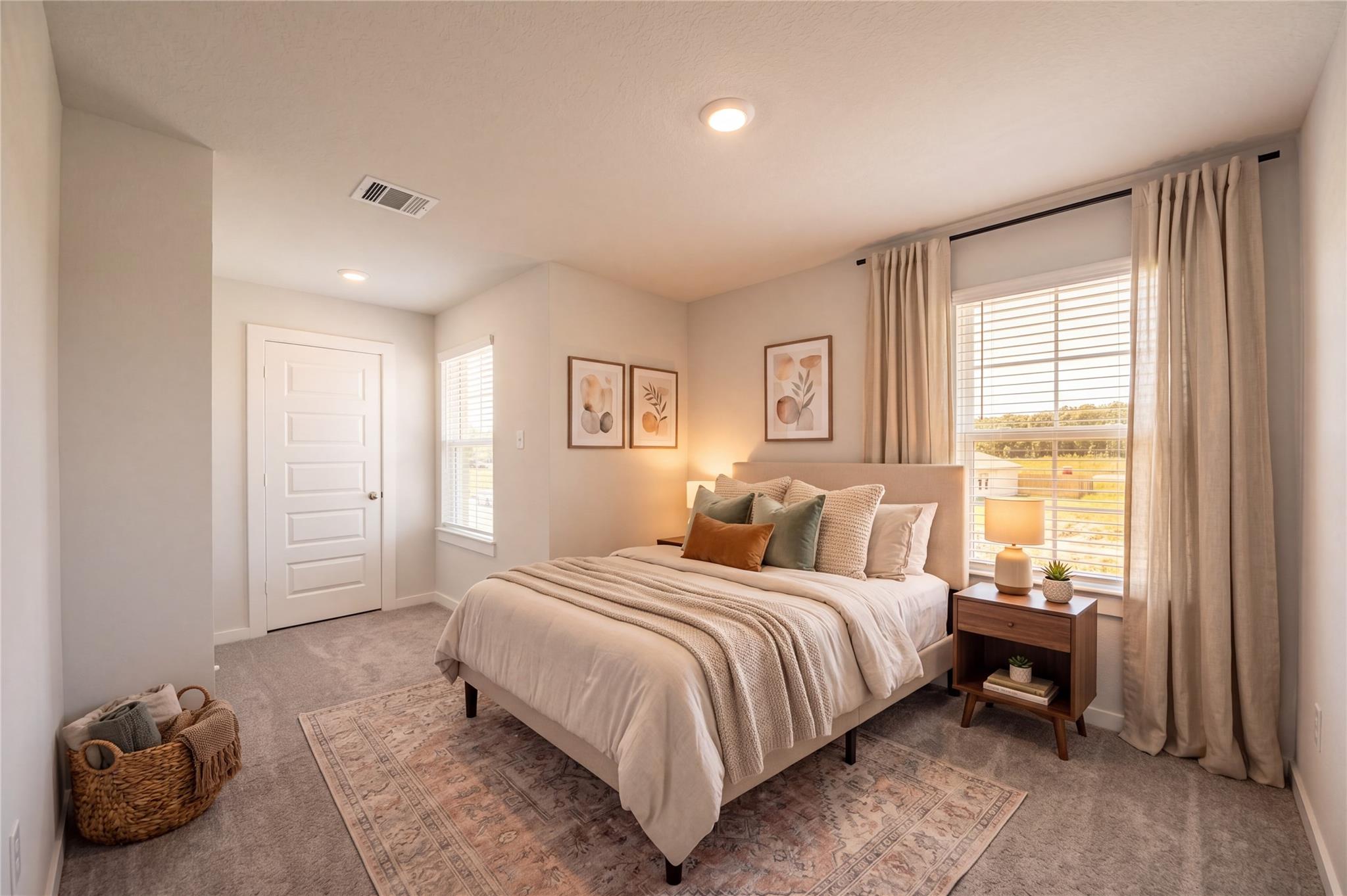 Bright neutral bedroom with upholstered bed and large windows in Davidson Homes' The Brazos F, Liberty Estates, Cleveland, TX