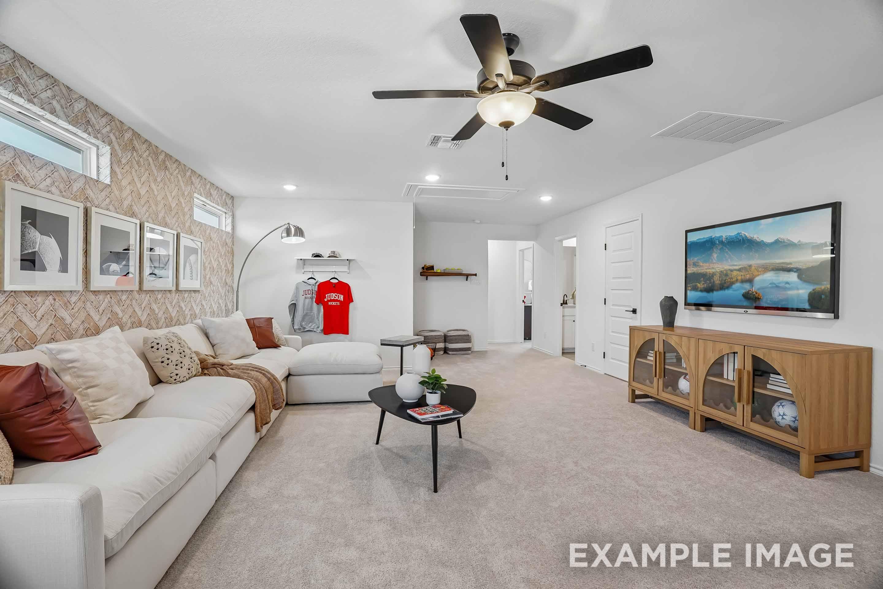 Spacious living room in The Pinecrest featuring a large sectional sofa, herringbone accent wall, and modern media console.