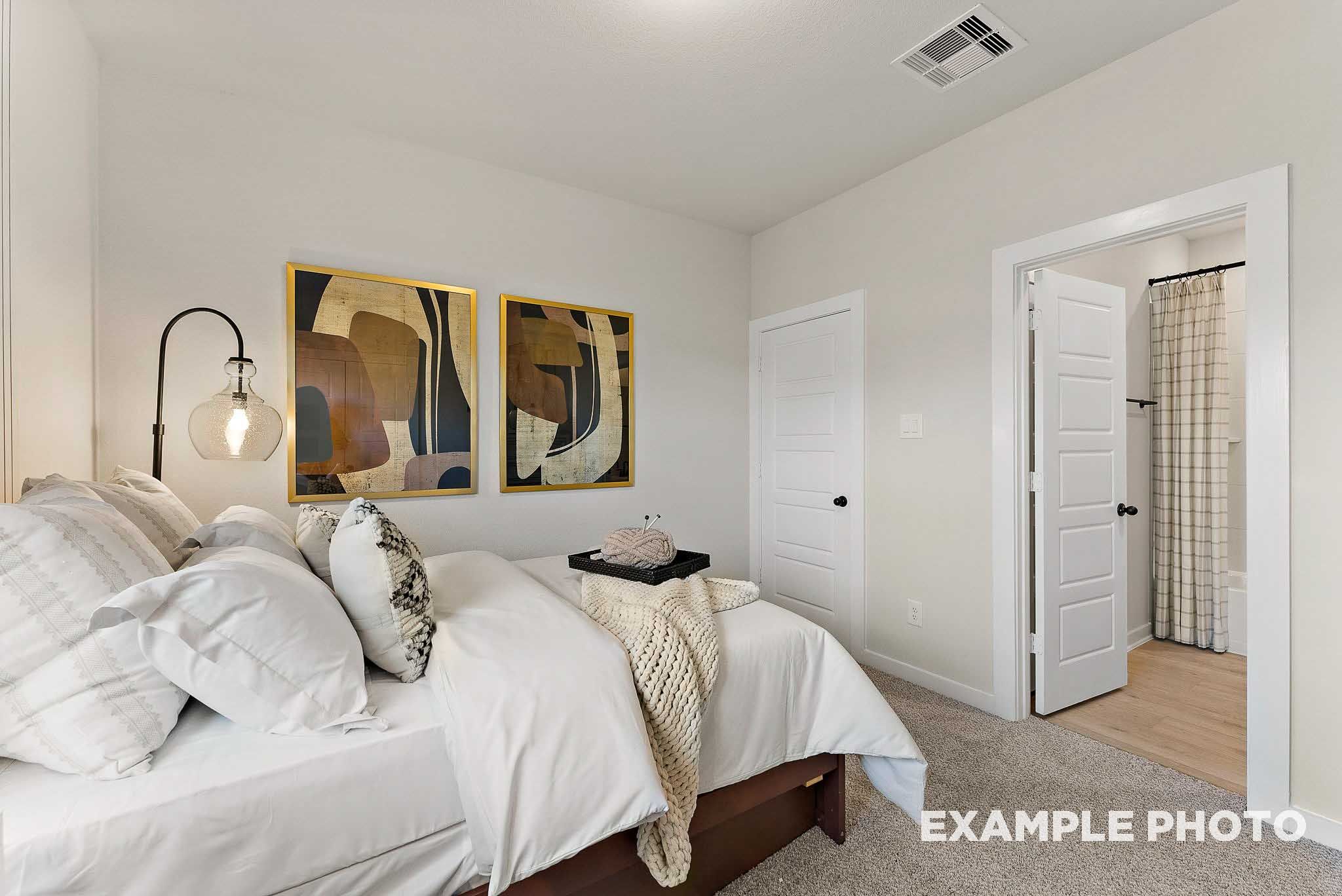Cozy bedroom with en-suite bath in The Everett E floor plan by Davidson Homes at Sundance Cove, Crosby, Texas.