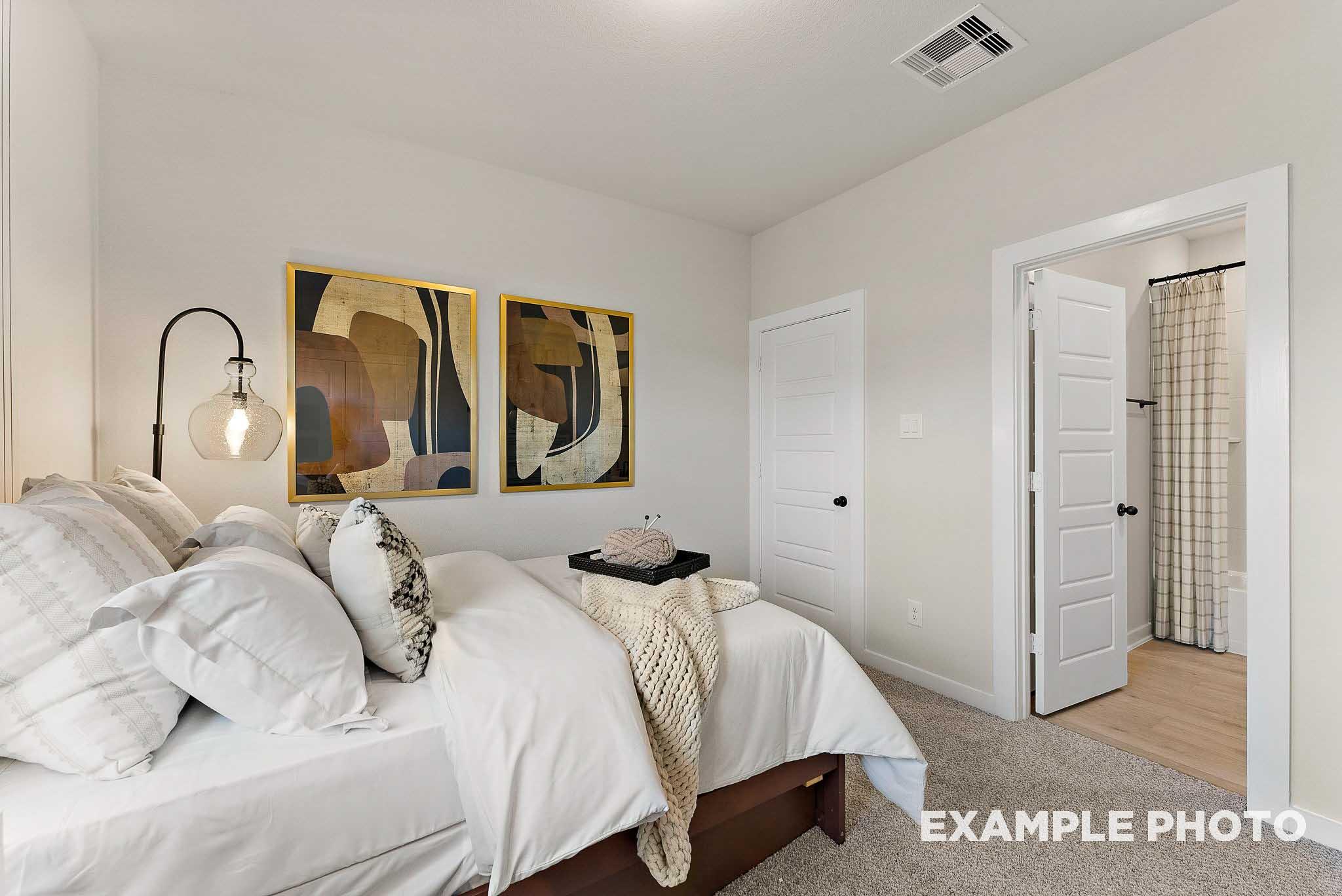 Cozy bedroom with en-suite bath in The Everett E floor plan by Davidson Homes at Sundance Cove, Crosby, Texas.