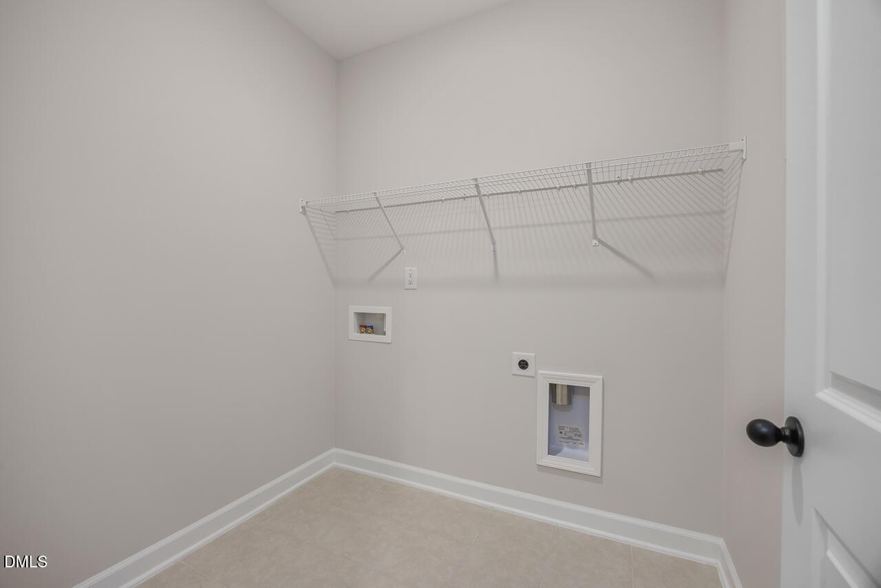 Spacious laundry room with wire shelving and washer/dryer hookups in Davidson Homes The Ash B, Lillington, NC