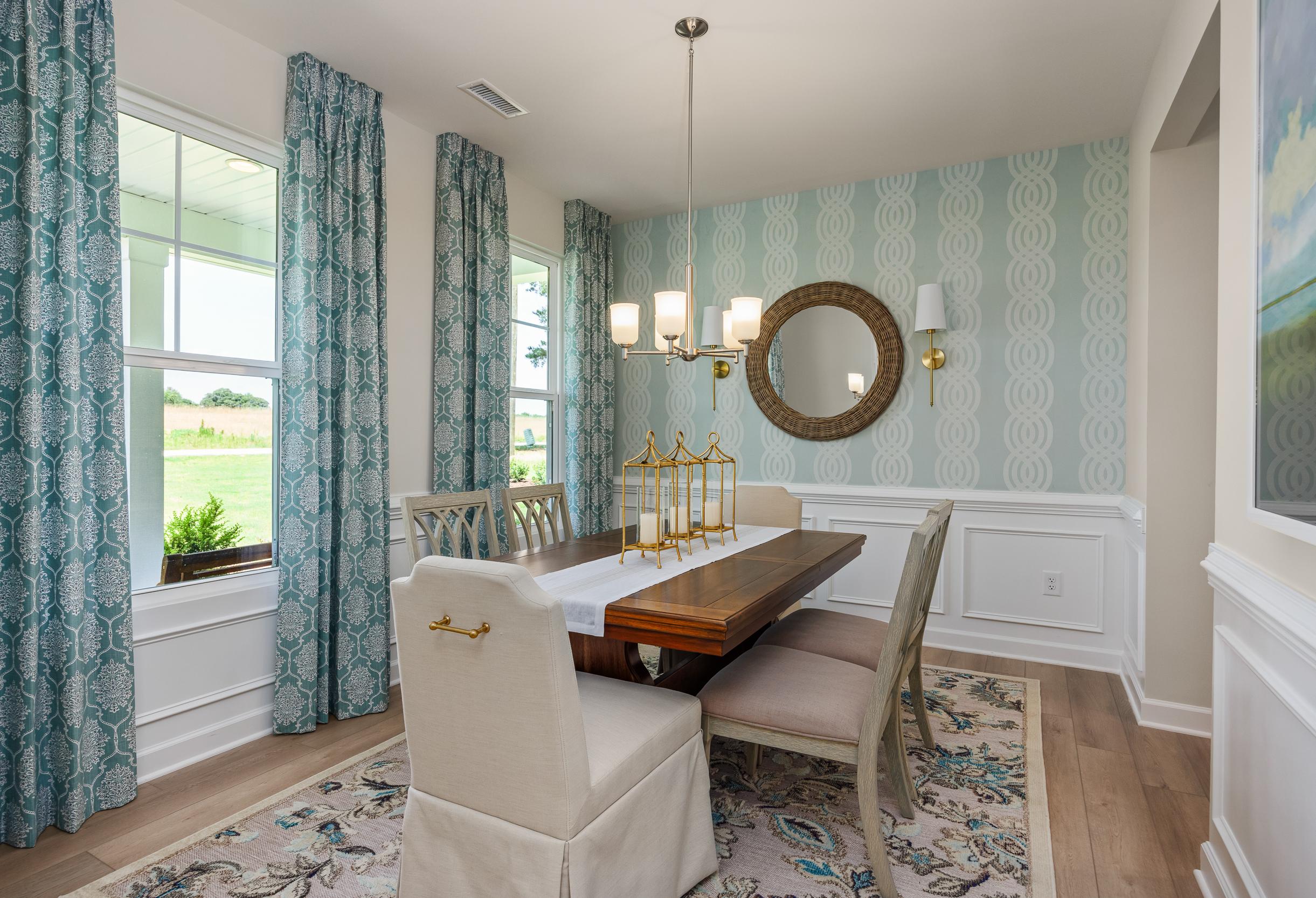 Bright dining room in The Willow B featuring elegant wainscoting, patterned wallpaper, and a modern chandelier.